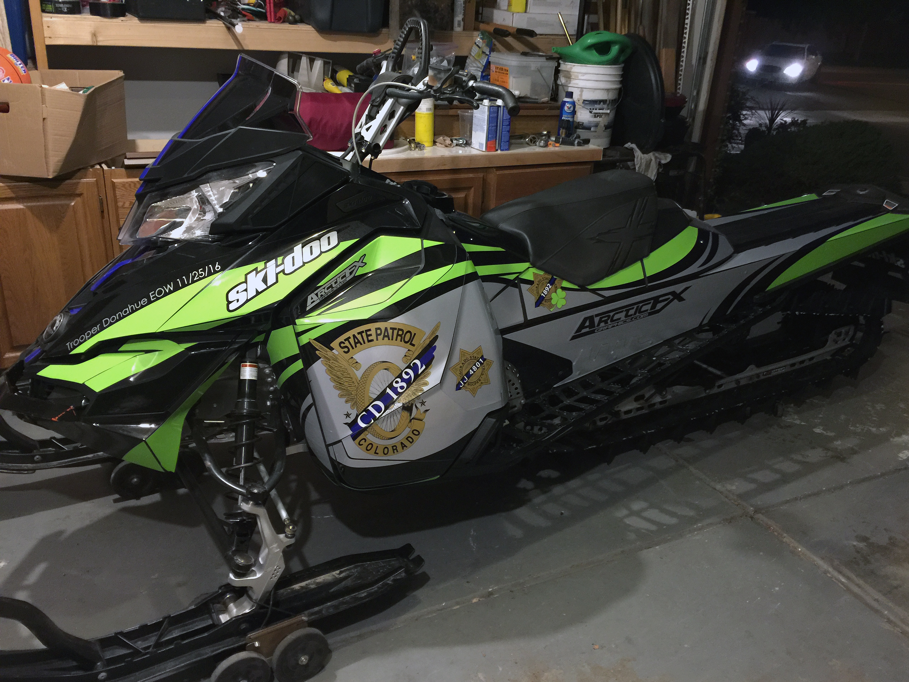 A Ski-Doo Rev XM snowmobile with a gray, manta, and black State Police custom vinyl wrap.