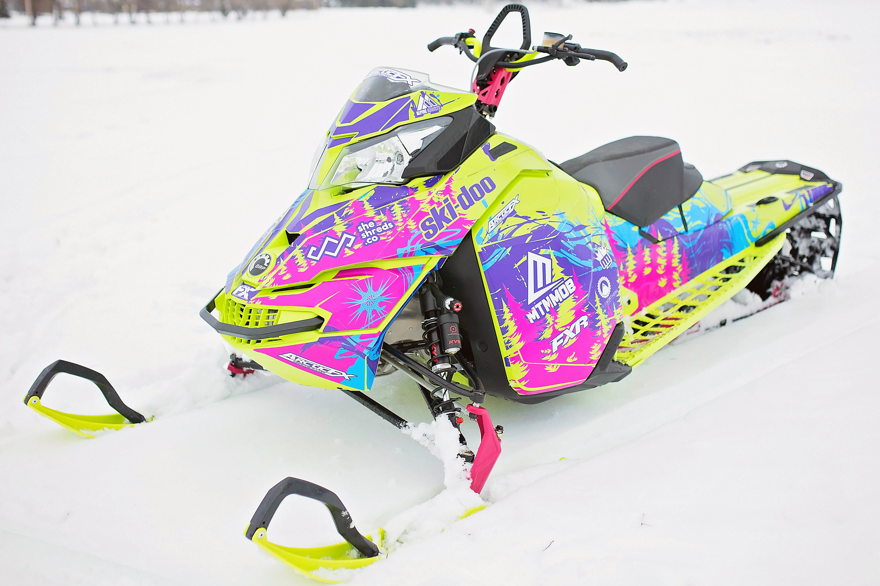 A Ski-Doo Rev XM snowmobile with a manta, octane blue, and purple Sub Zero custom vinyl wrap.