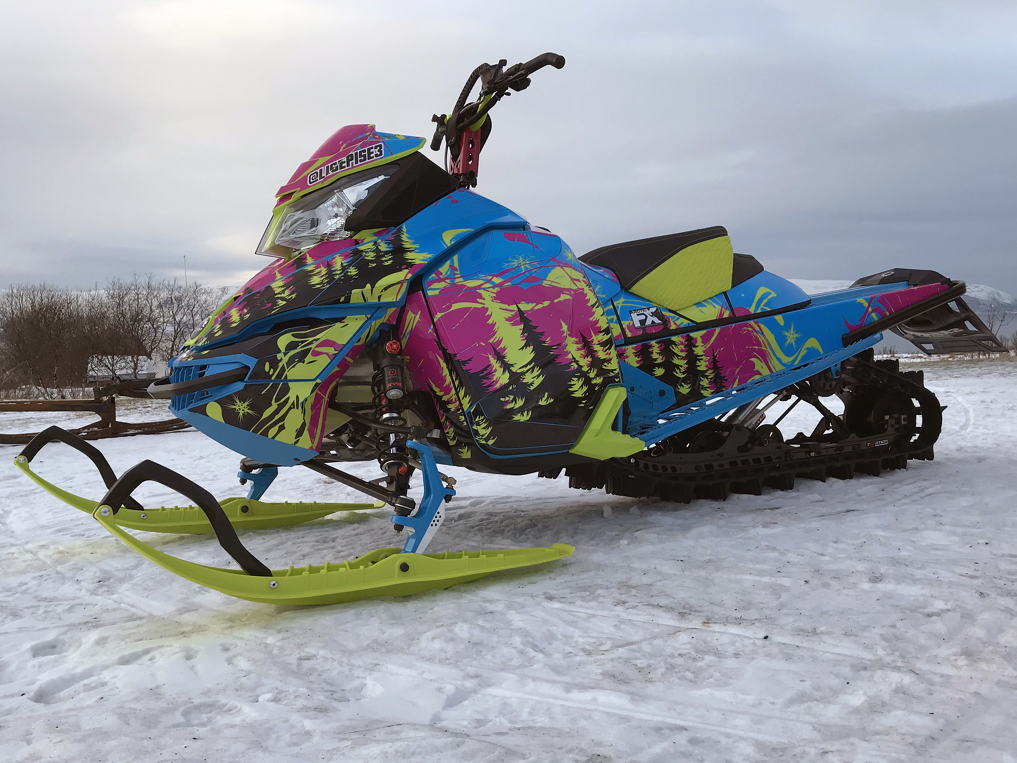 A Ski-Doo Rev XM snowmobile with a manta, octane blue, and pink Sub Zero custom vinyl wrap.