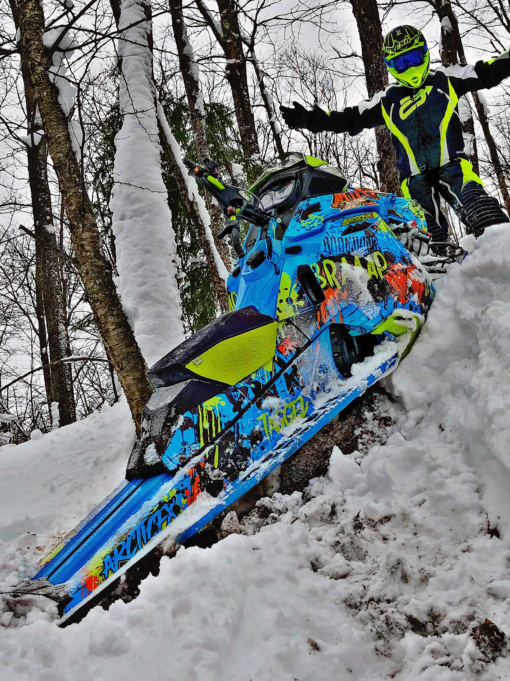 A Ski-Doo Rev XM snowmobile with a manta, octane blue, and black Tagged custom vinyl wrap.
