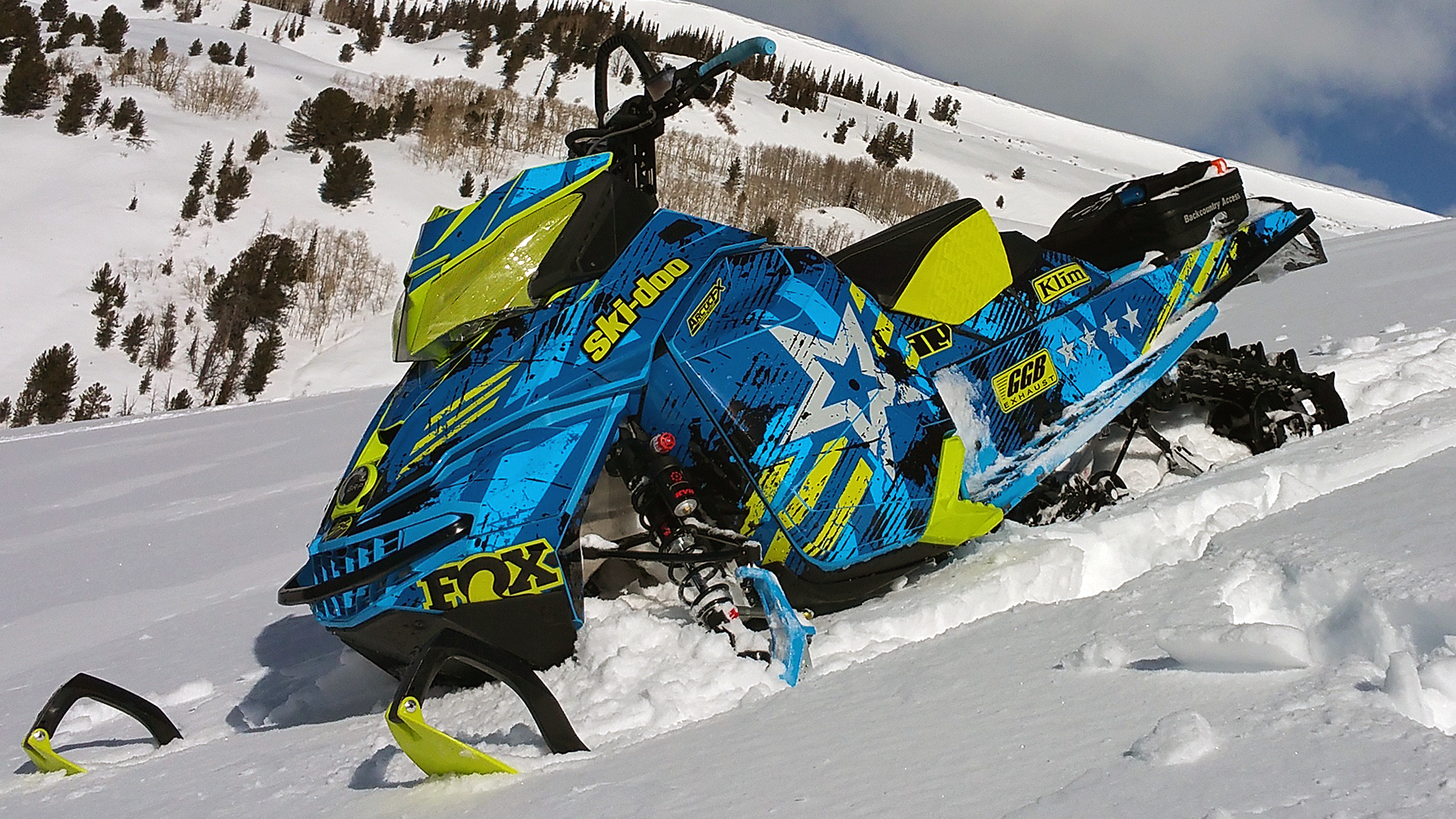 A Ski-Doo Rev XM snowmobile with a manta and octane blue grunge star Wartorn custom vinyl wrap.