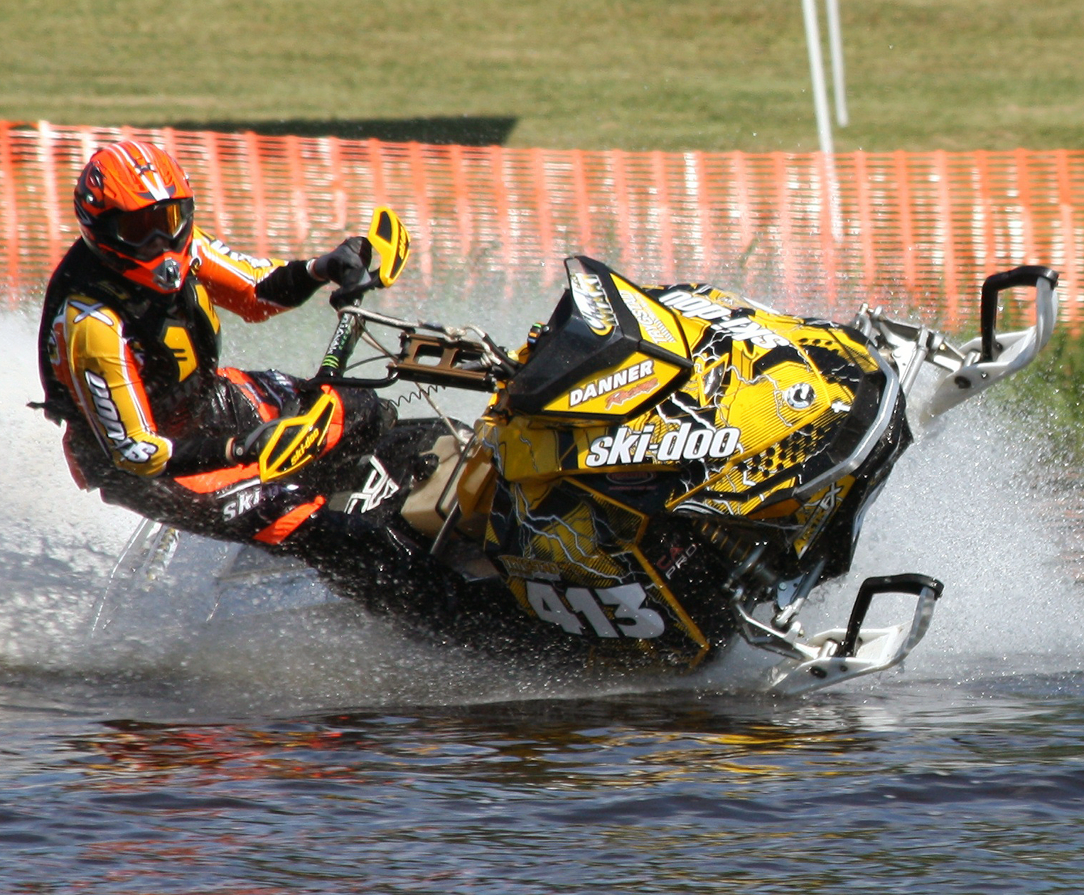 A Ski-Doo Rev XP snowmobile with a yellow, white, and black lightning Hard Rain custom vinyl wrap.