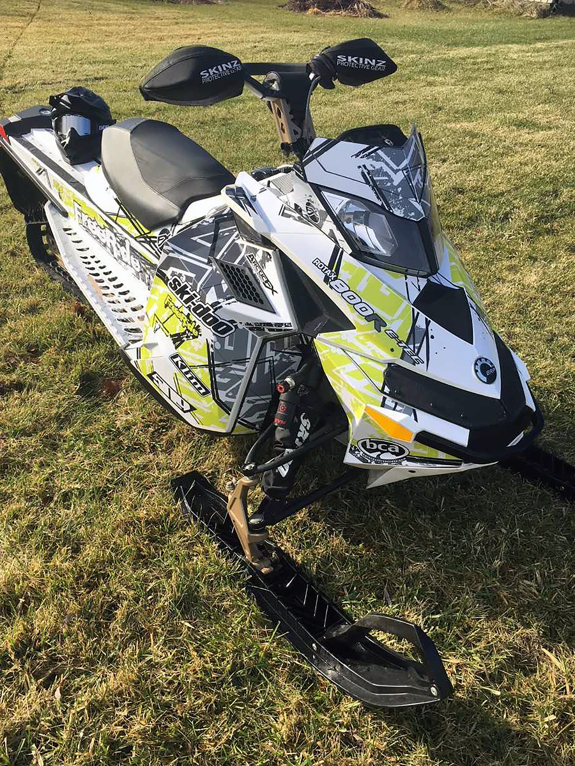 A Ski-Doo Rev XP snowmobile with a manta, gray, and white Havoc custom vinyl wrap.
