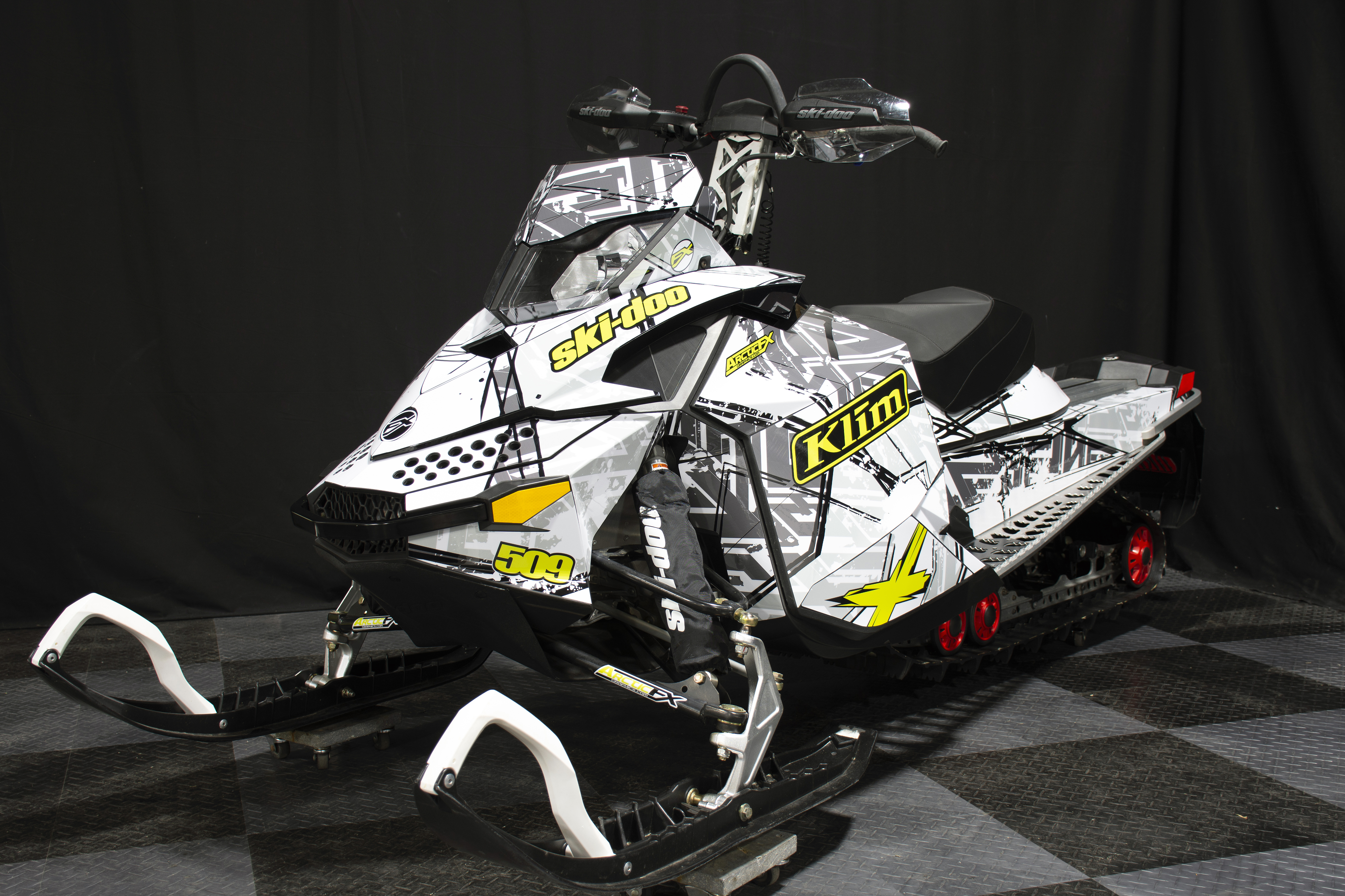 A Ski-Doo Rev XP snowmobile with a manta, gray, and white Havoc custom vinyl wrap.