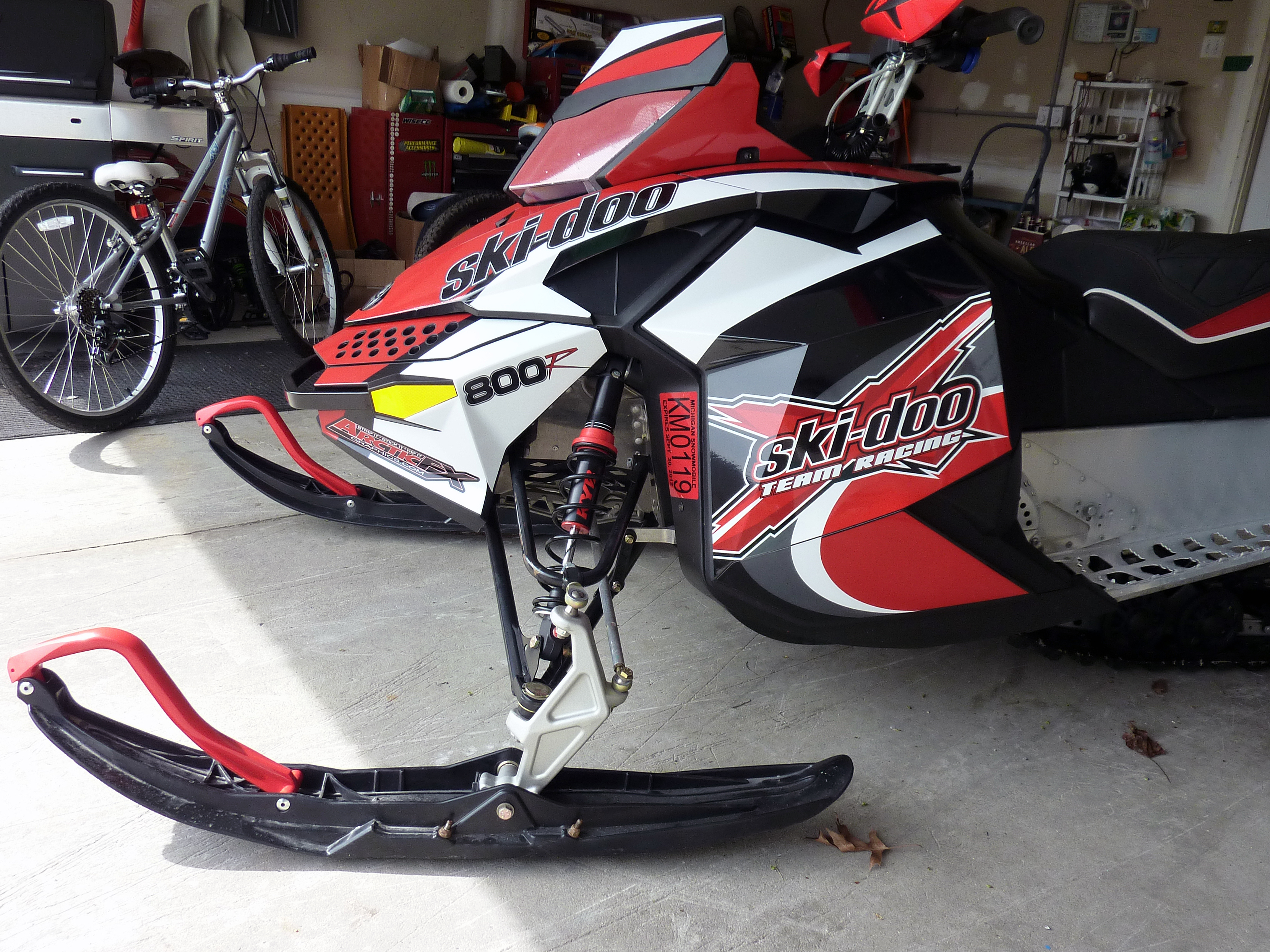 A Ski-Doo Rev XP snowmobile with a black, white, and red Team Maki custom vinyl wrap.