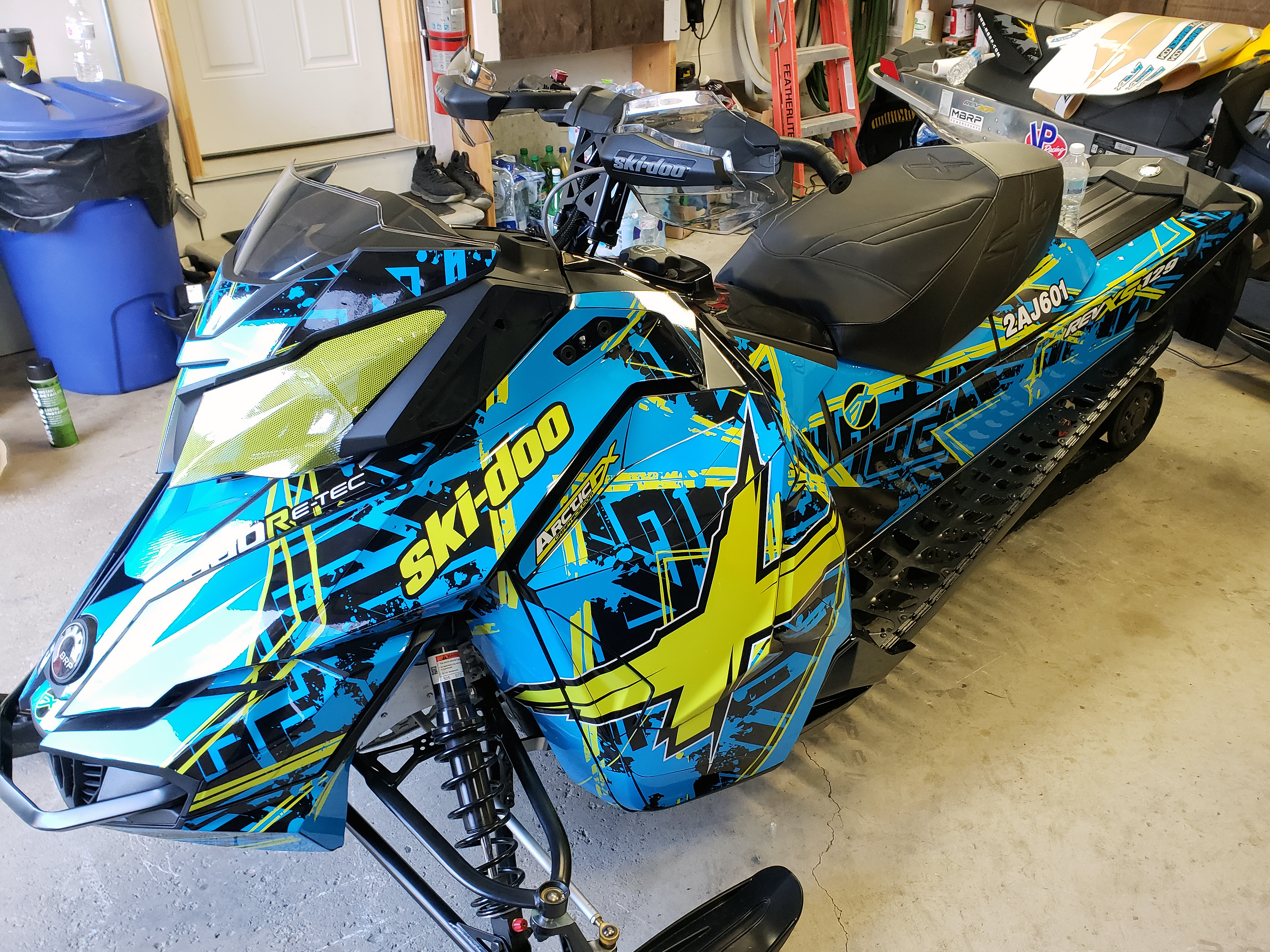 A Ski-Doo Rev XS snowmobile with a octane blue, manta, and black Havoc custom vinyl wrap.