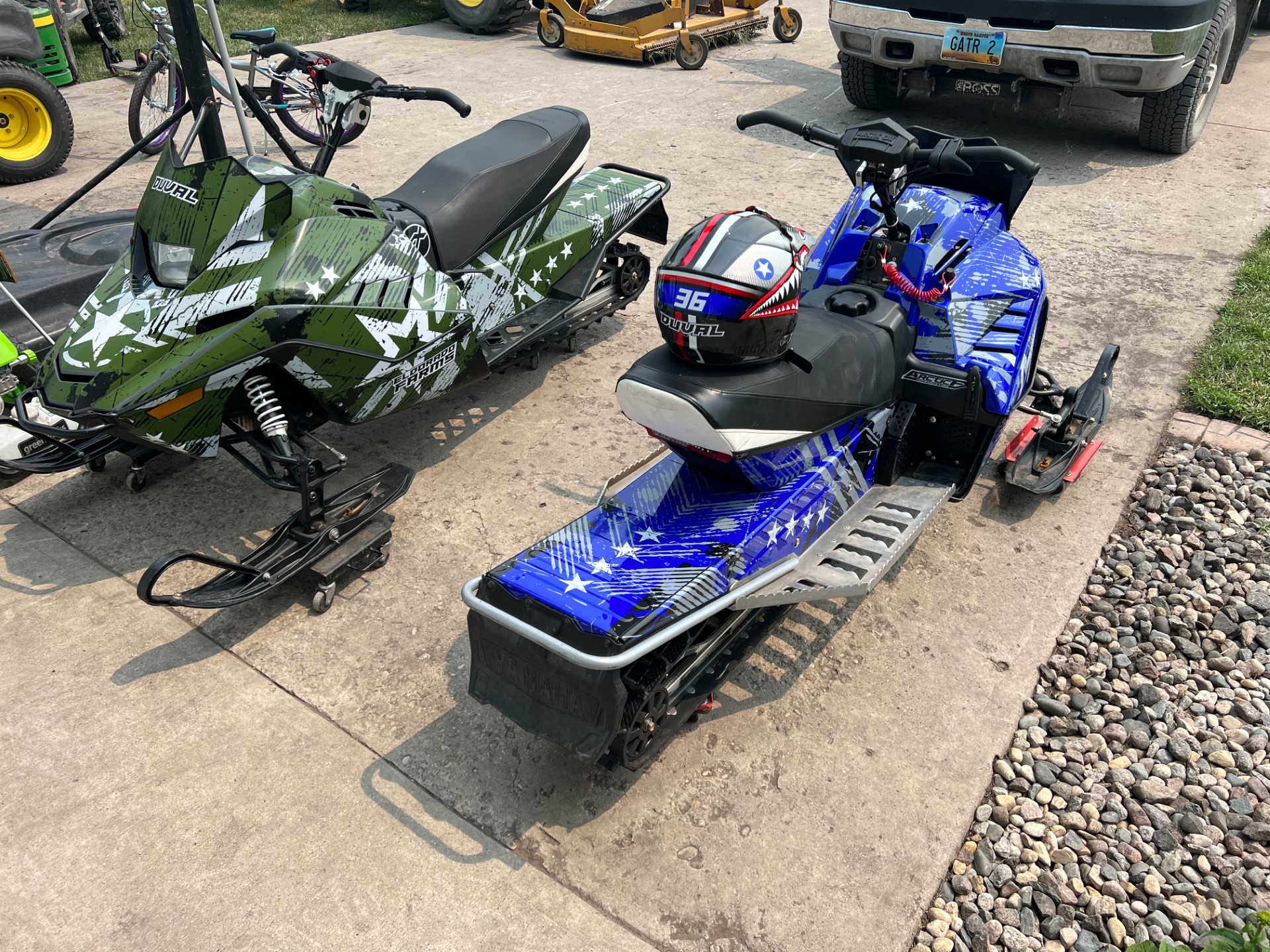 An Arctic Cat ZR200 youth snowmobile with a blue and green Wartorn custom vinyl wrap.