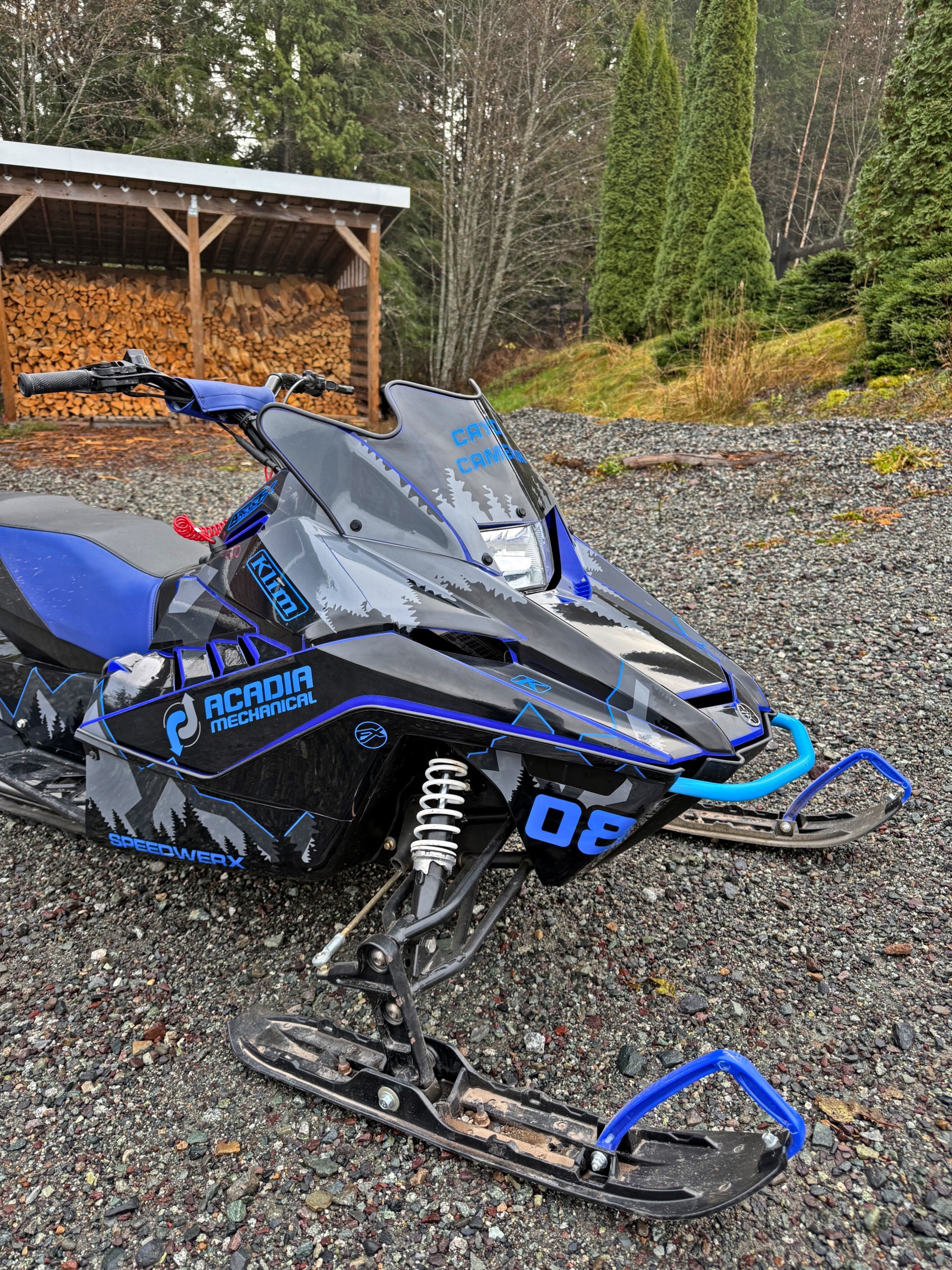 A Yamaha Snoscoot snowmobile with a black, gunmetal gray, asphalt gray, and blue KLIM Legacy custom vinyl wrap.
