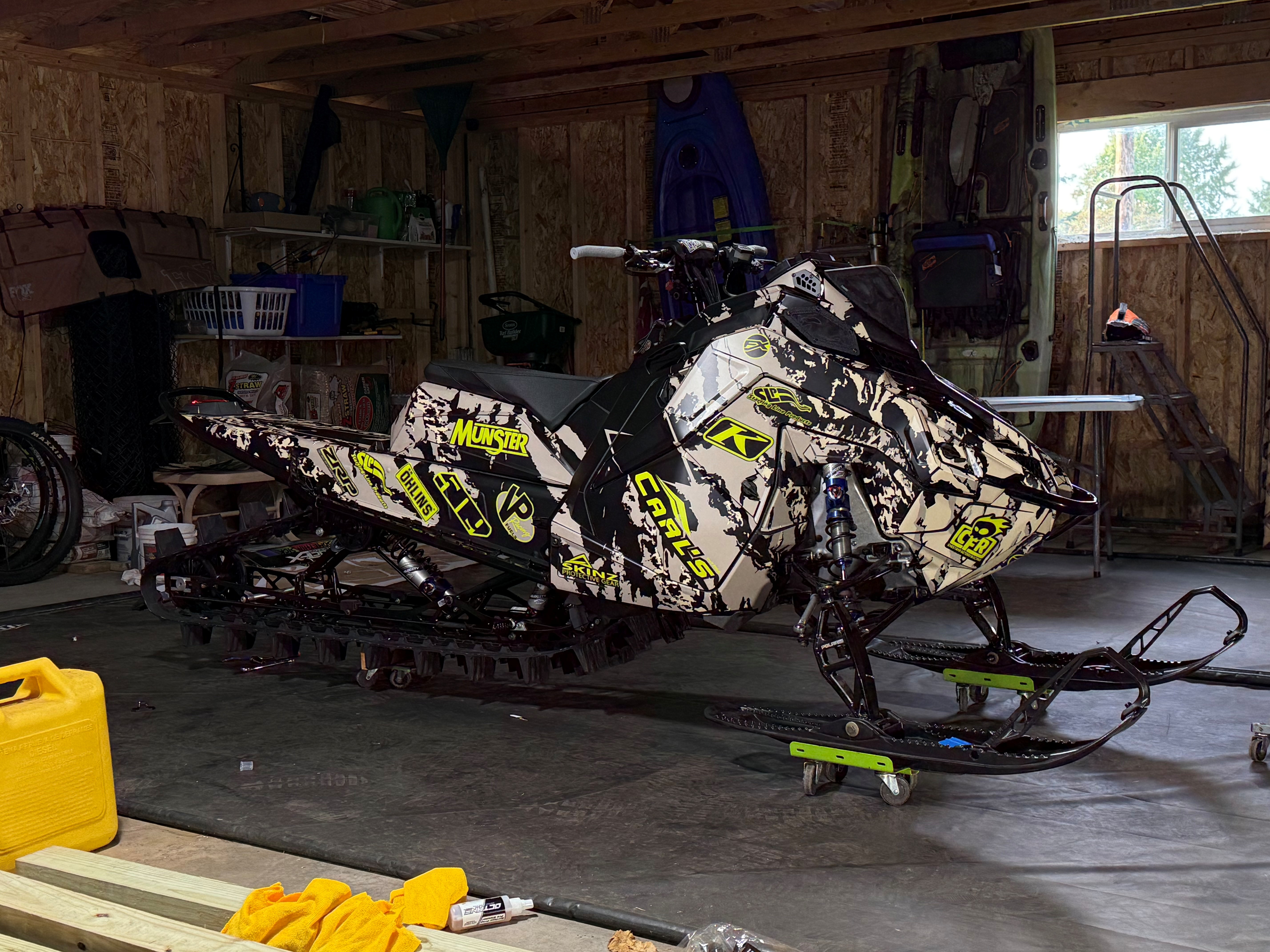A Polaris Matryx Mountain snowmobile with a black, arctic desert, beige and manta green Adams Inversion custom vinyl wrap with matte laminate