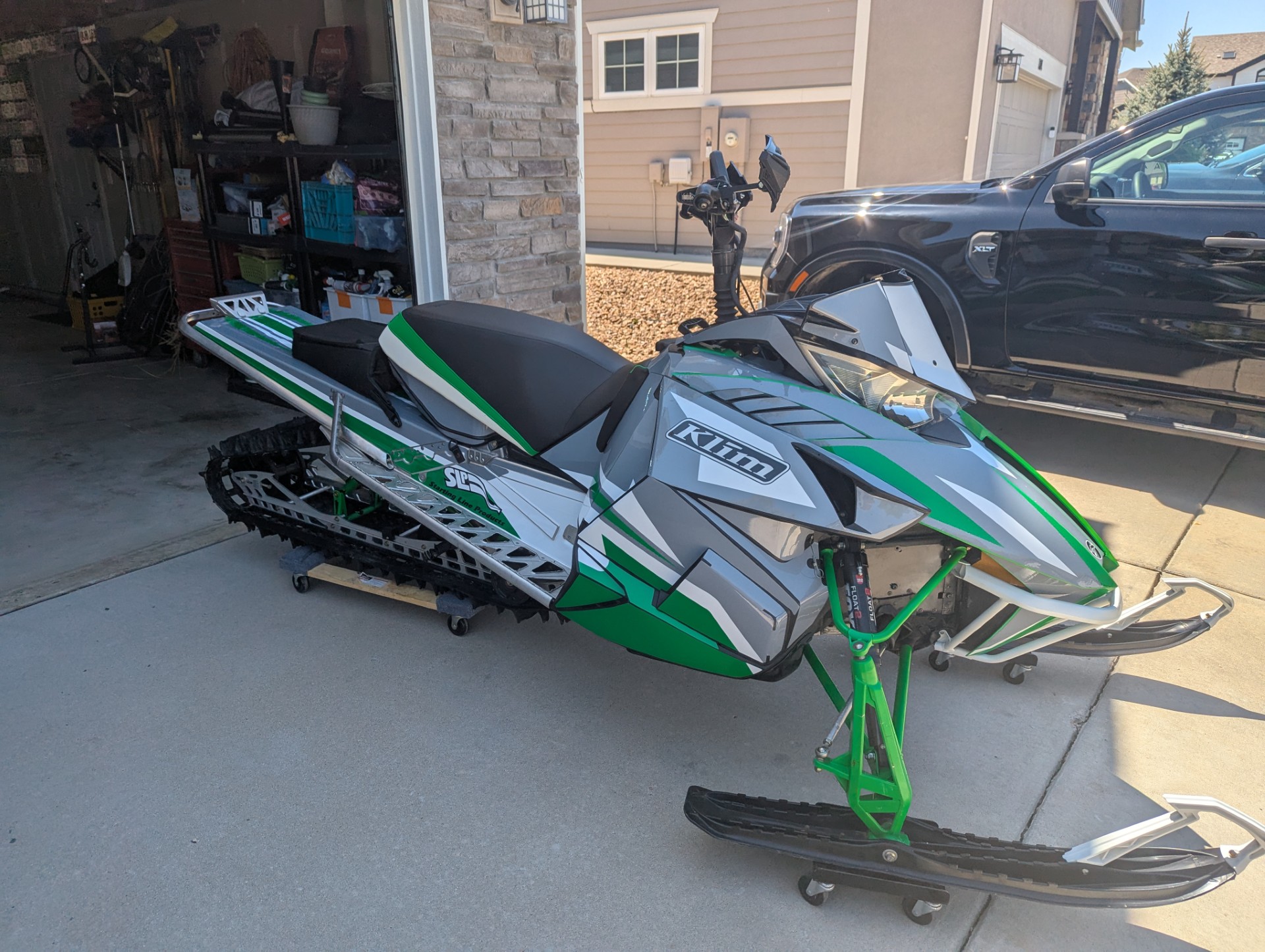A ArcticCat Proclimb snowmobile with a white, black, monument gray, and pearl green Justin Thomas Velocity custom vinyl wrap.