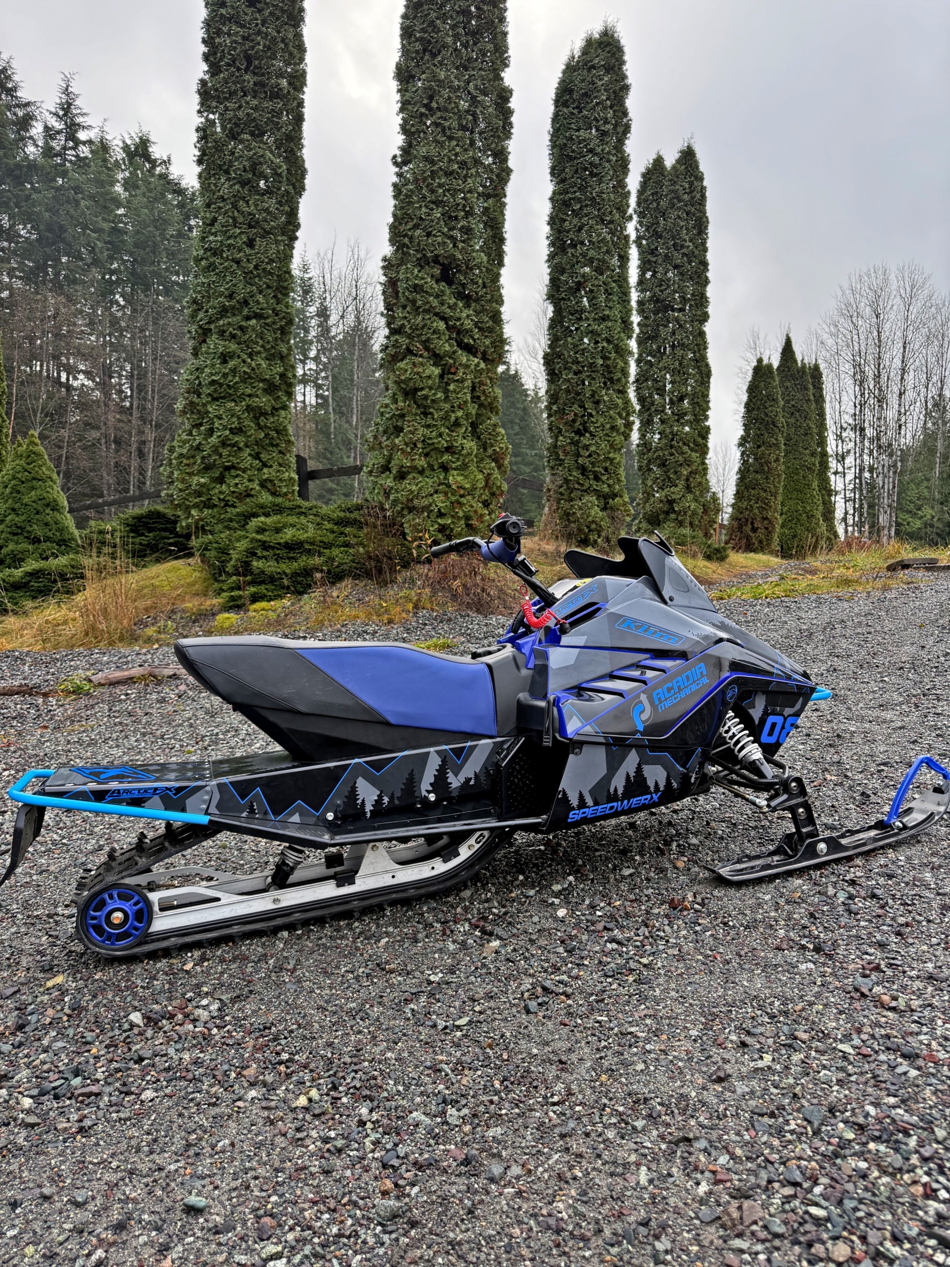 A Yamaha Snoscoot snowmobile with a black, gunmetal gray, asphalt gray, and blue KLIM Legacy custom vinyl wrap.