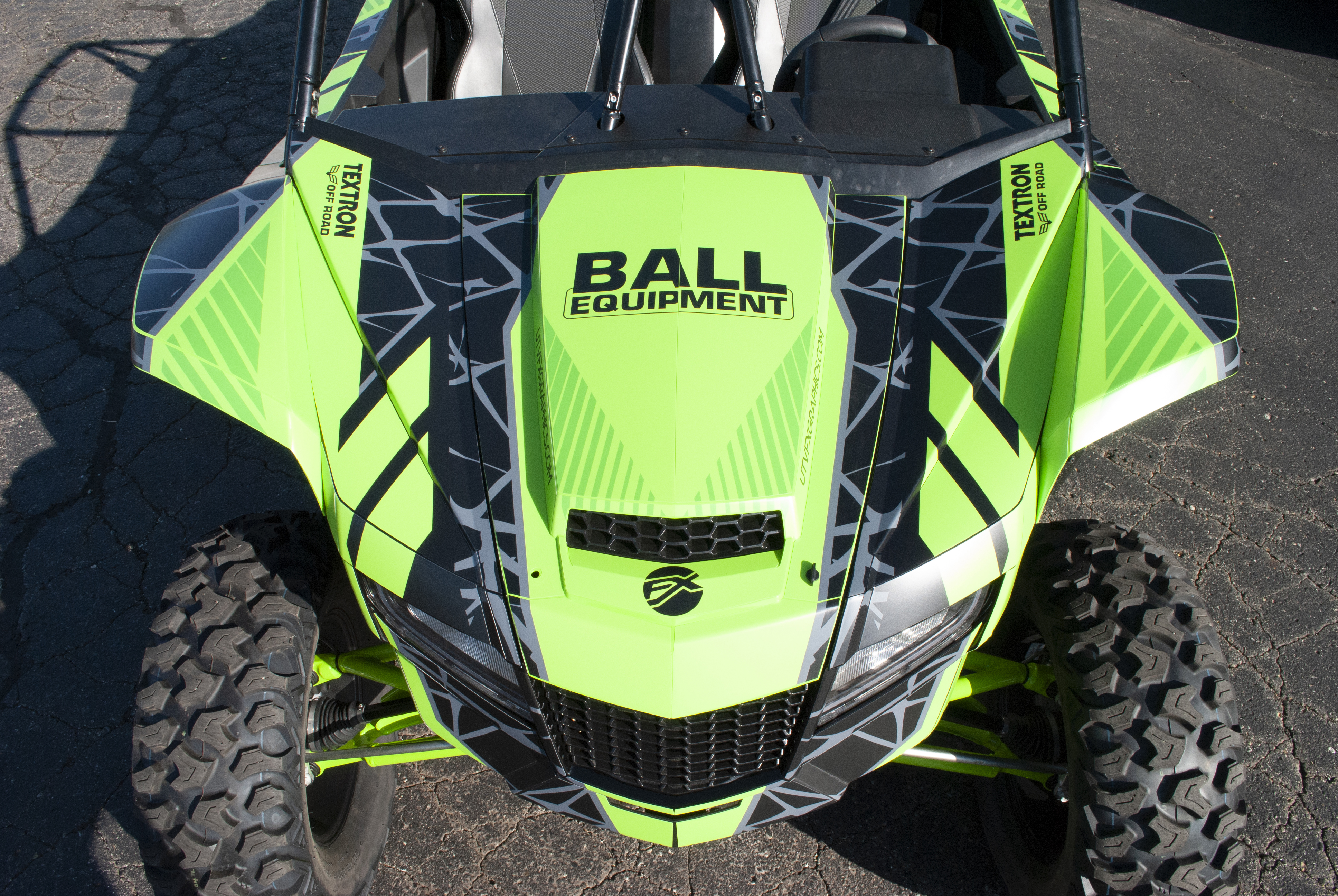 A Arctic Cat Wildcat XX side-by-side with a green, black, and dark gray Fractal custom vinyl wrap.