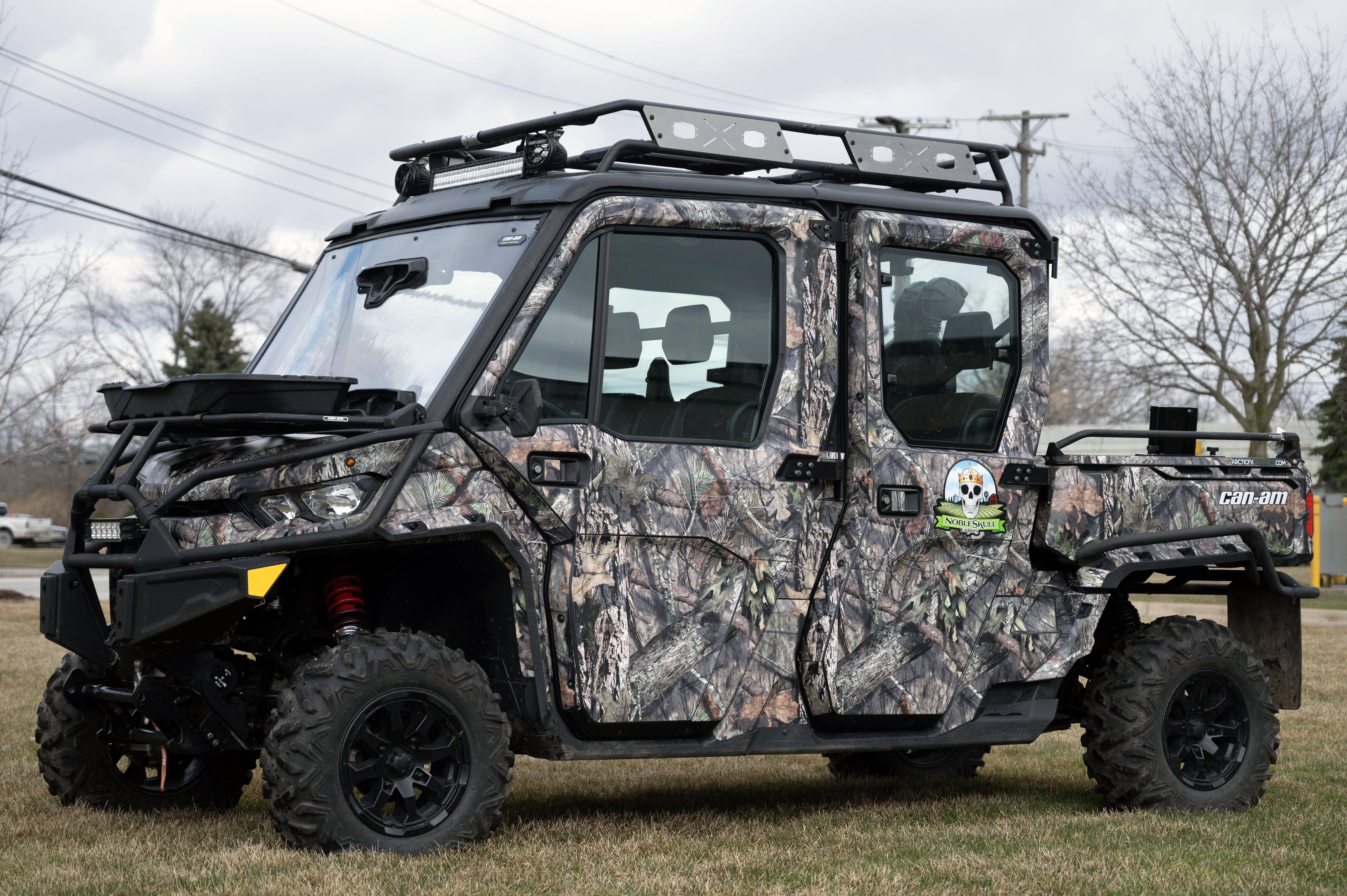 A Can-Am Defender Max side-by-side with a real tree camouflage pattern custom vinyl wrap.