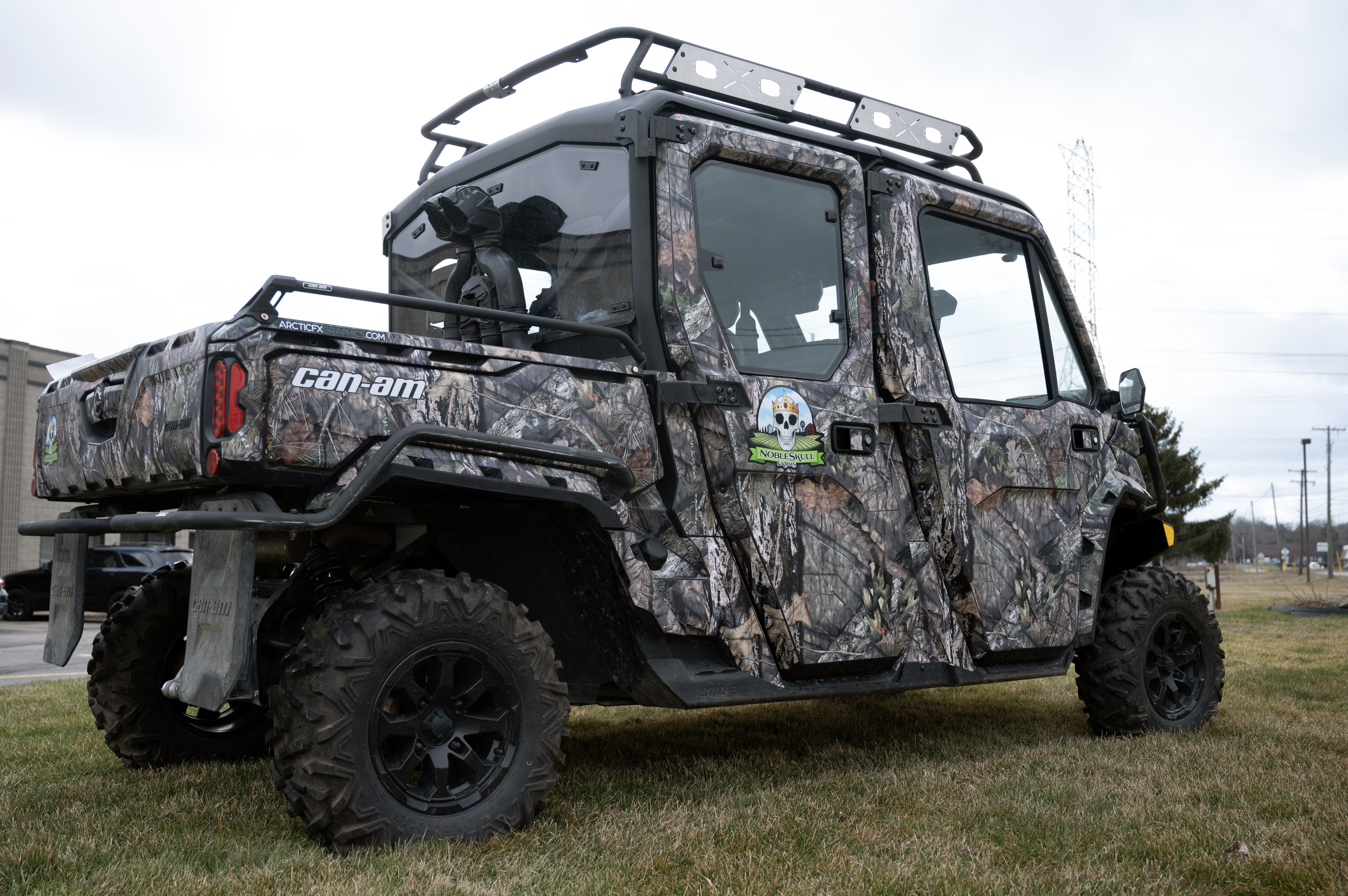 A Can-Am Defender Max side-by-side with a real tree camouflage pattern custom vinyl wrap.