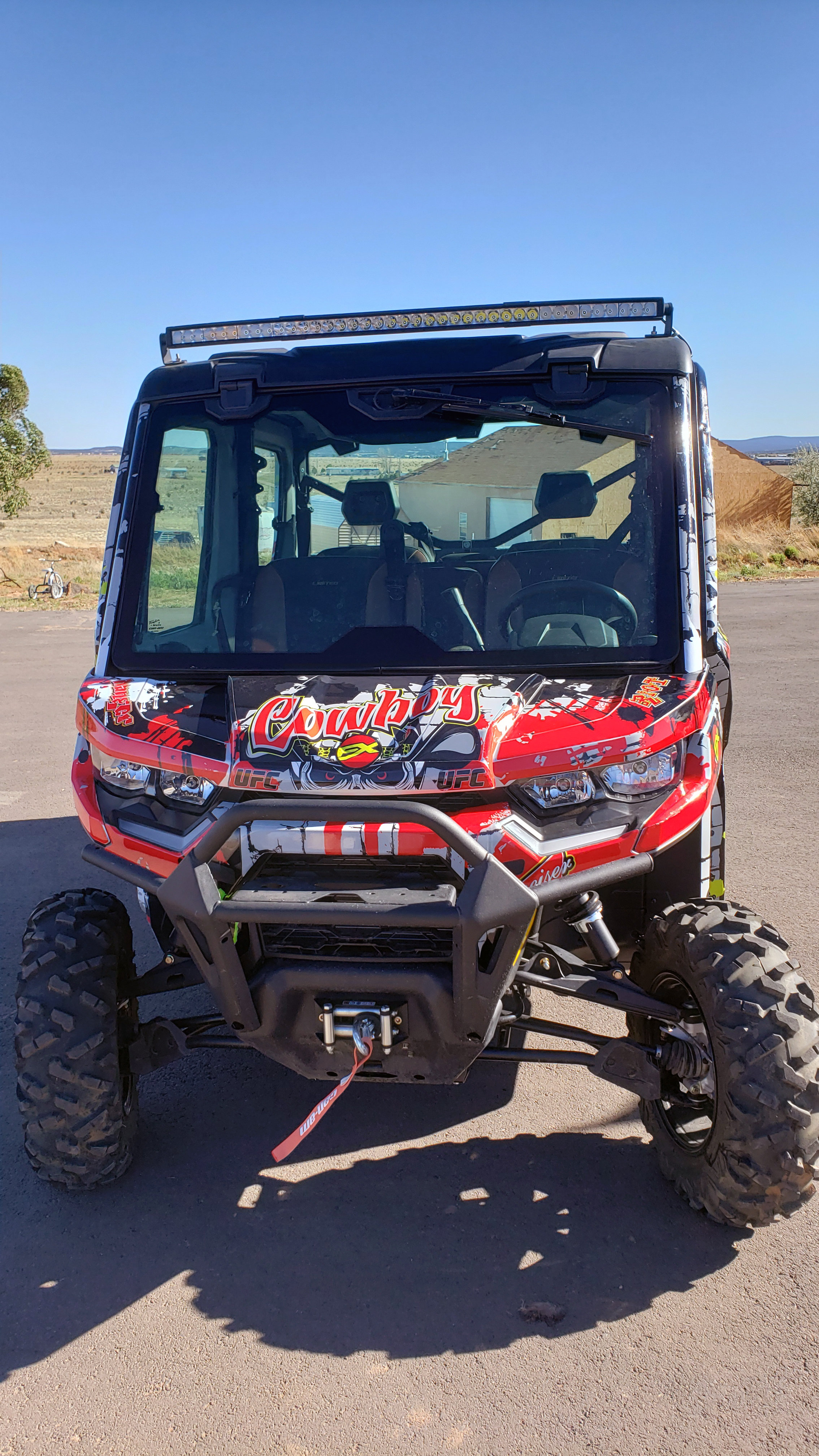 A Can-Am Defender Max side-by-side with a red, white, and black grunge skull Cowboy Cerrone UFC custom vinyl wrap.