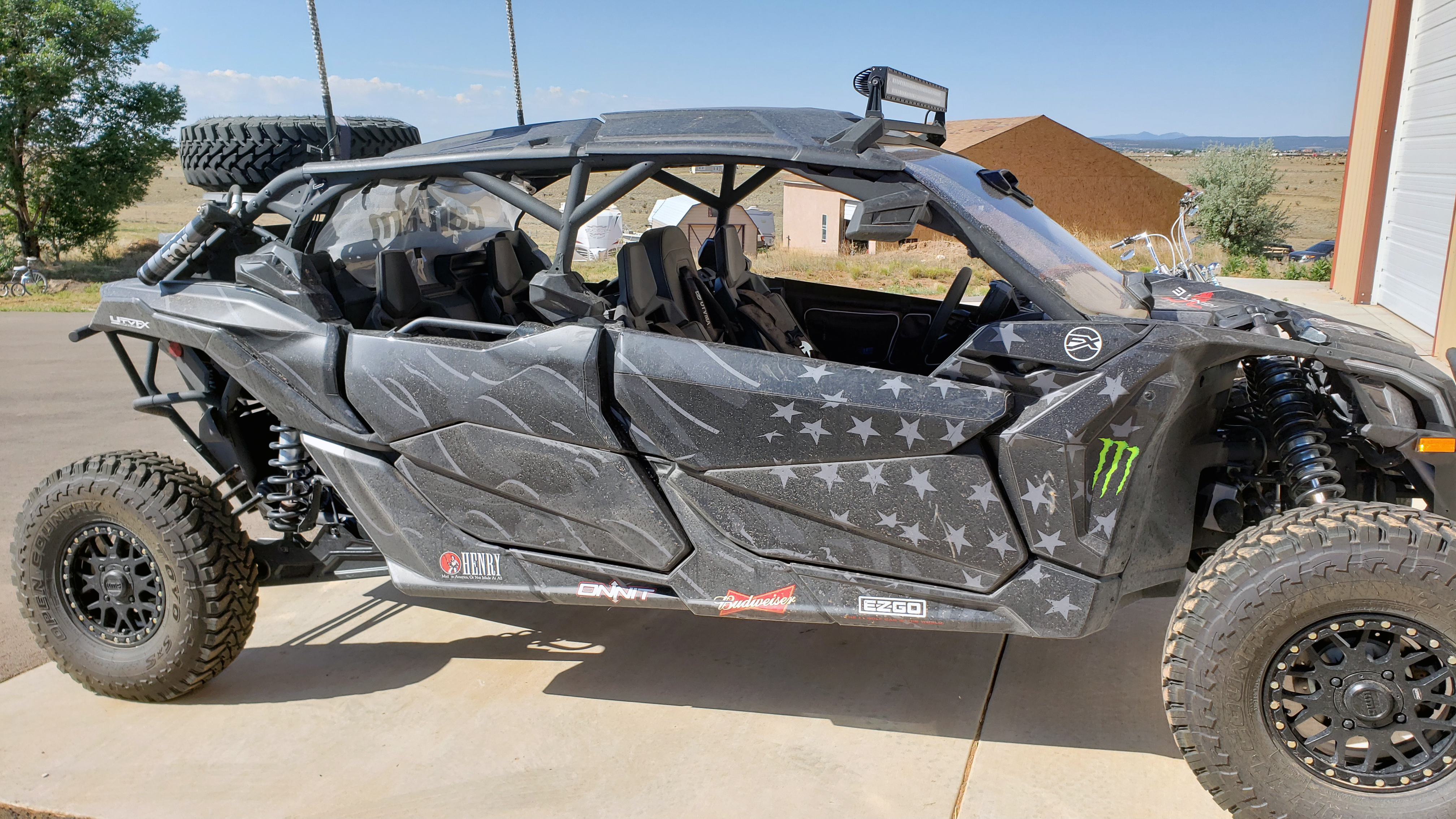 A Can-Am Maverick X3 Max side-by-side with a black and dark gray grunge American Flag custom vinyl wrap.