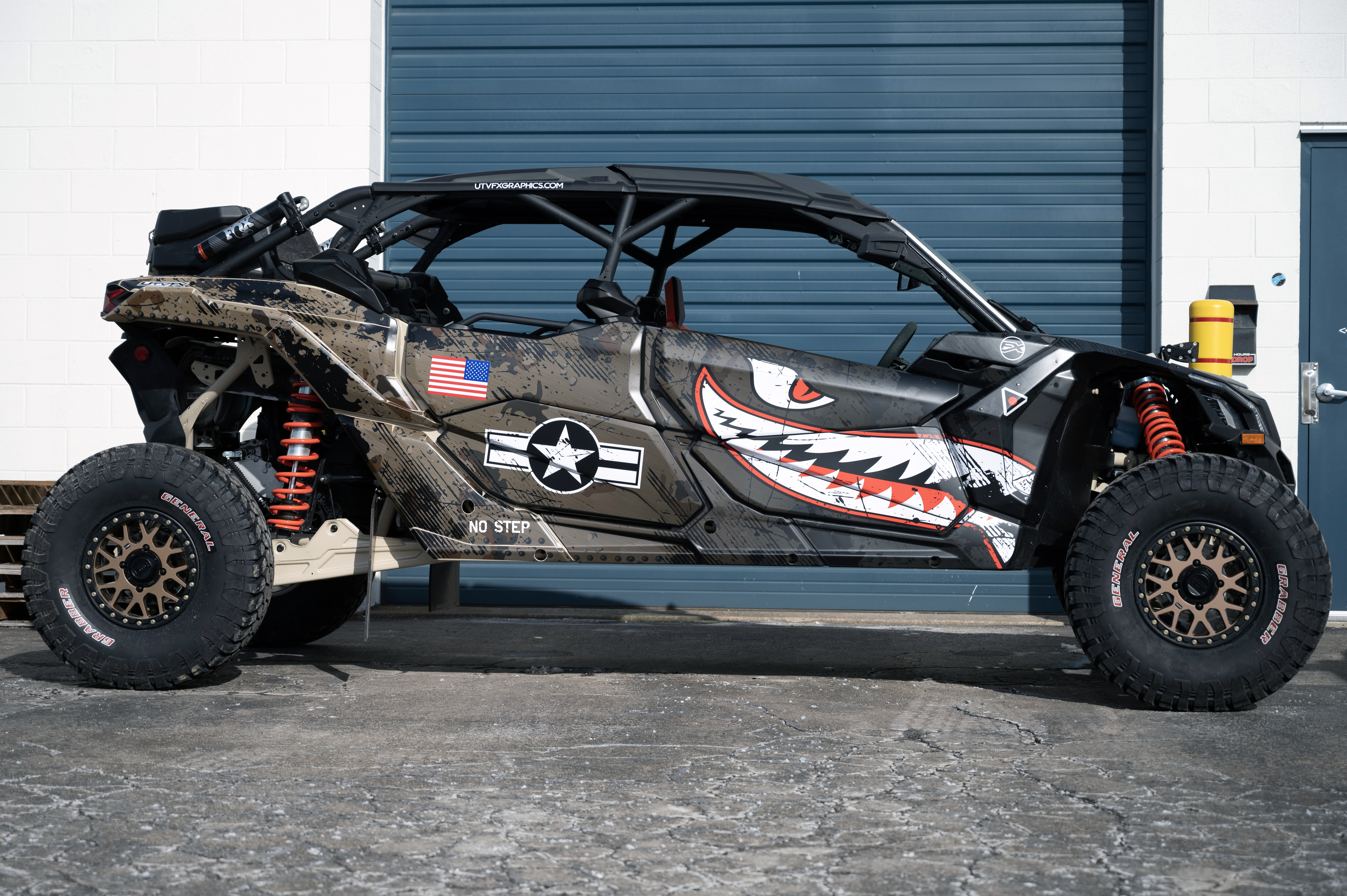 A Can-Am Maverick X3 Max side-by-side with a black, tan, and red tiger shark plane custom vinyl wrap.