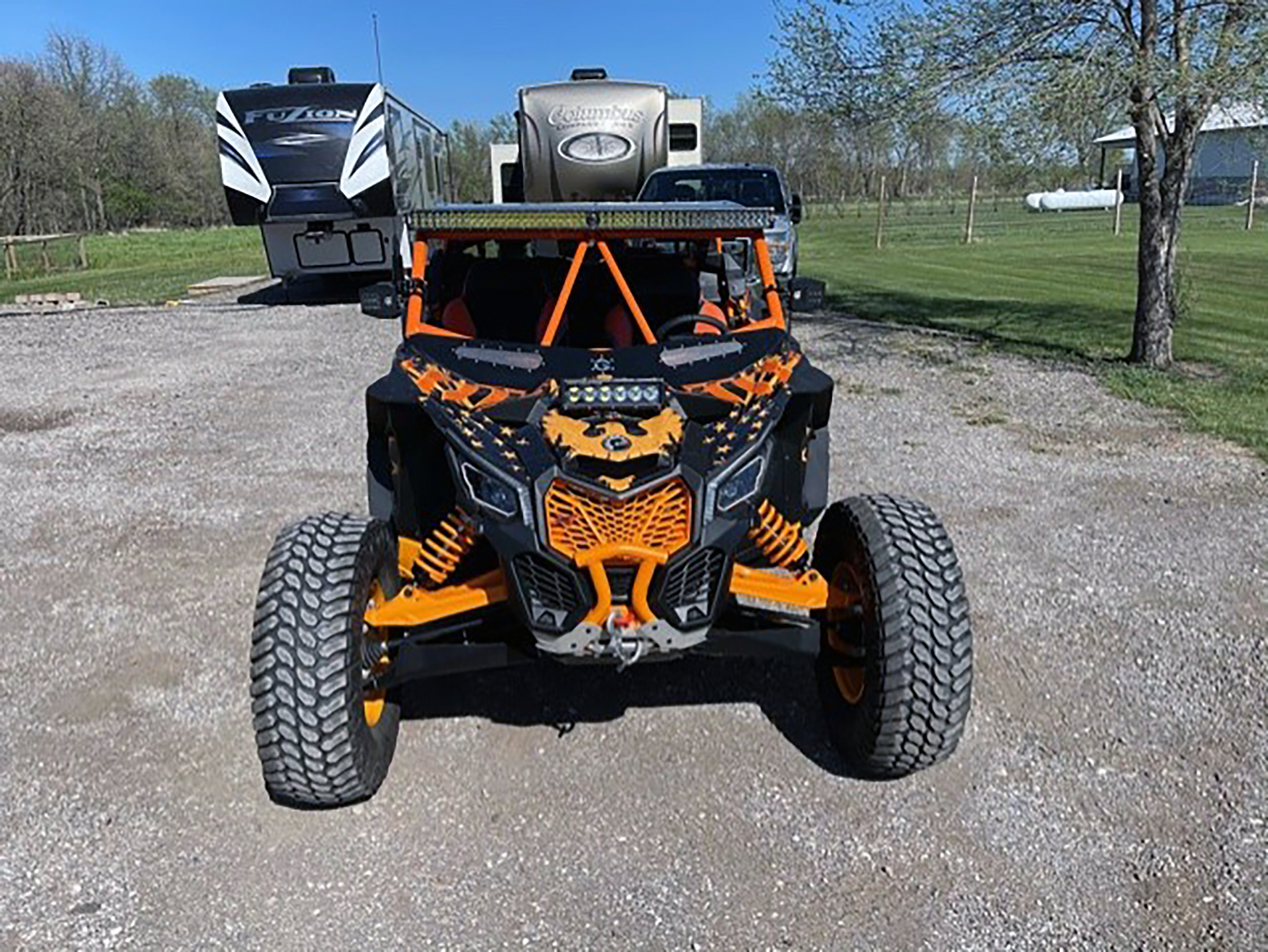 A Can-Am Maverick X3 side-by-side with a orange and  black grunge American Flag custom vinyl wrap.