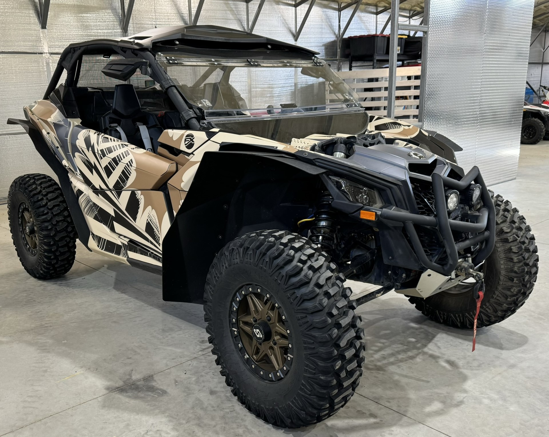 A Can-Am Maverick X3 side-by-side with a Delirious custom vinyl wrap