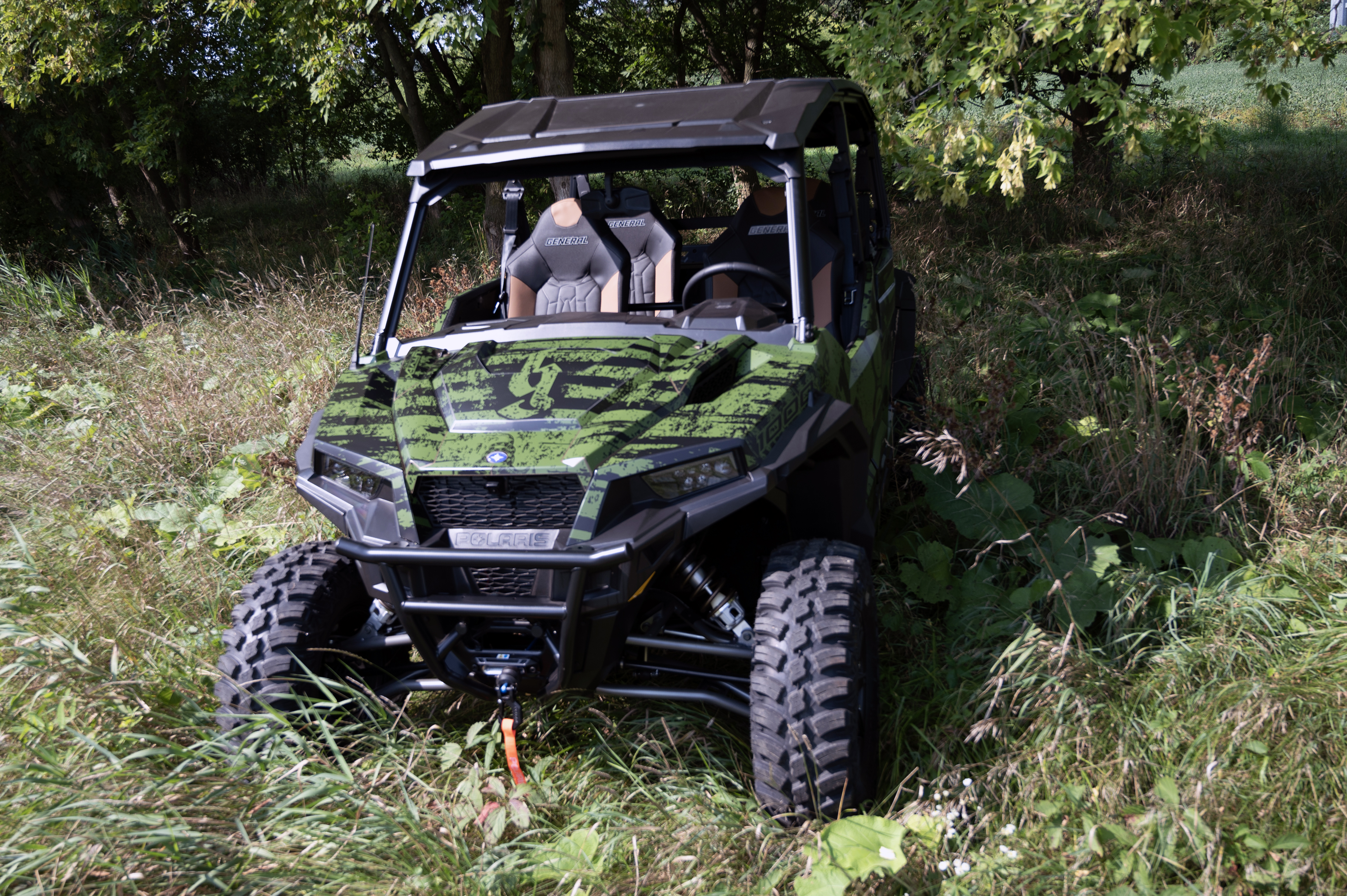 A Polaris General 4 Door side-by-side with a green, black, American Flag custom vinyl wrap.