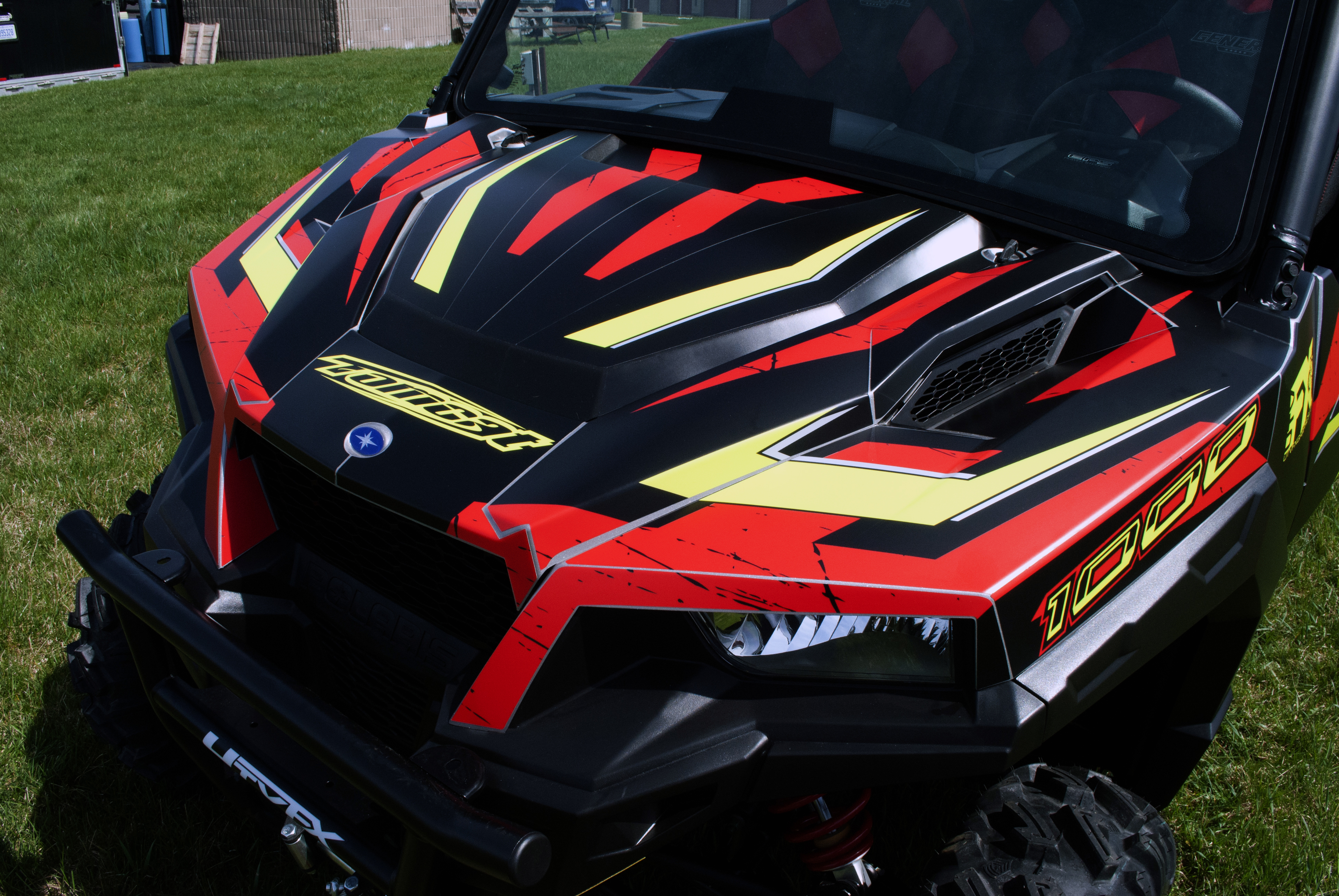 A Polaris General 4 Door side-by-side with a black, red and lime Rogue custom vinyl wrap.
