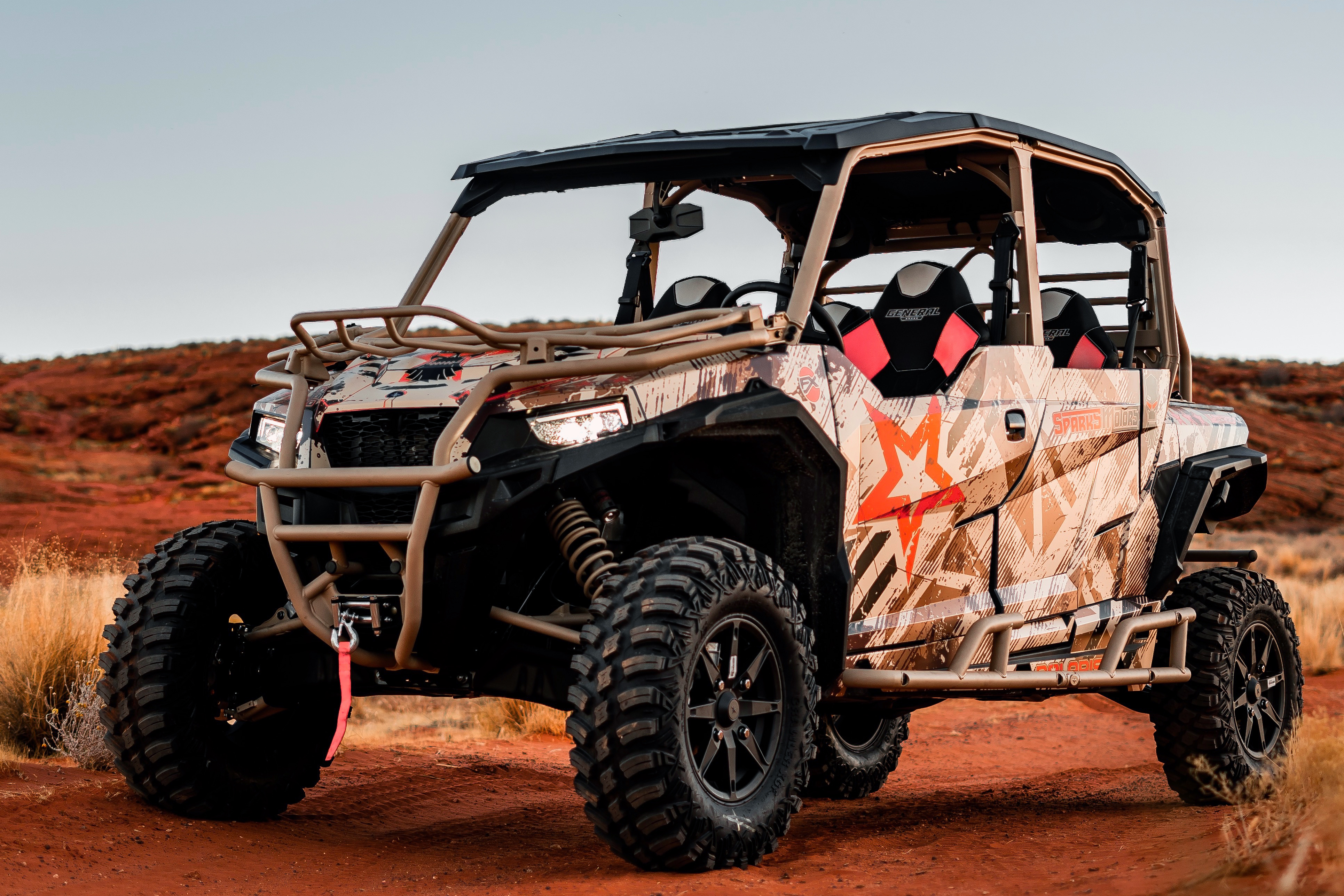 A Polaris General 4 Door side-by-side with a white, black, and orange grunge Wartorn custom vinyl wrap.