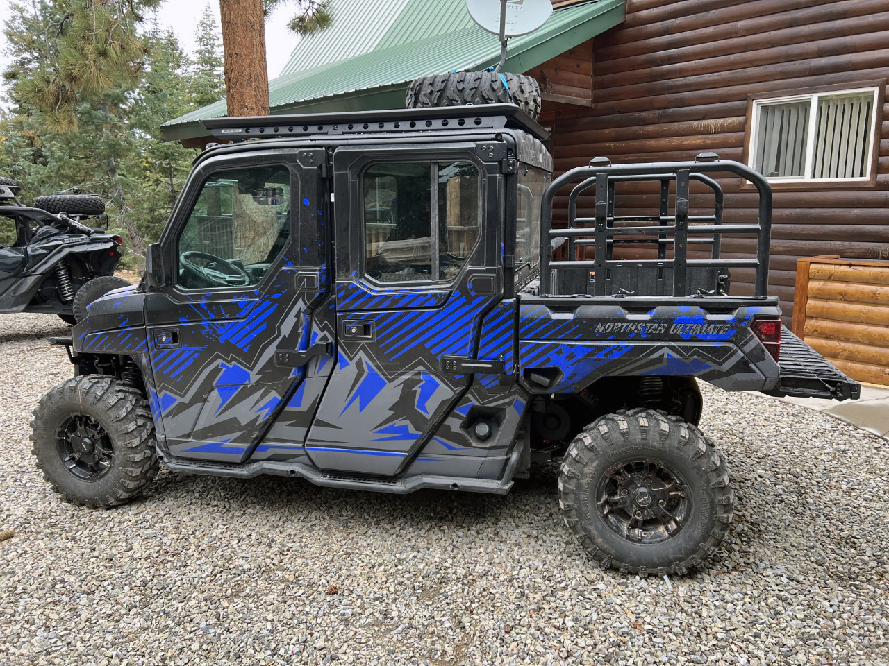 A Polaris Ranger 4 Door side-by-side with a blue, black, and gray mountain Altitude custom vinyl wrap.