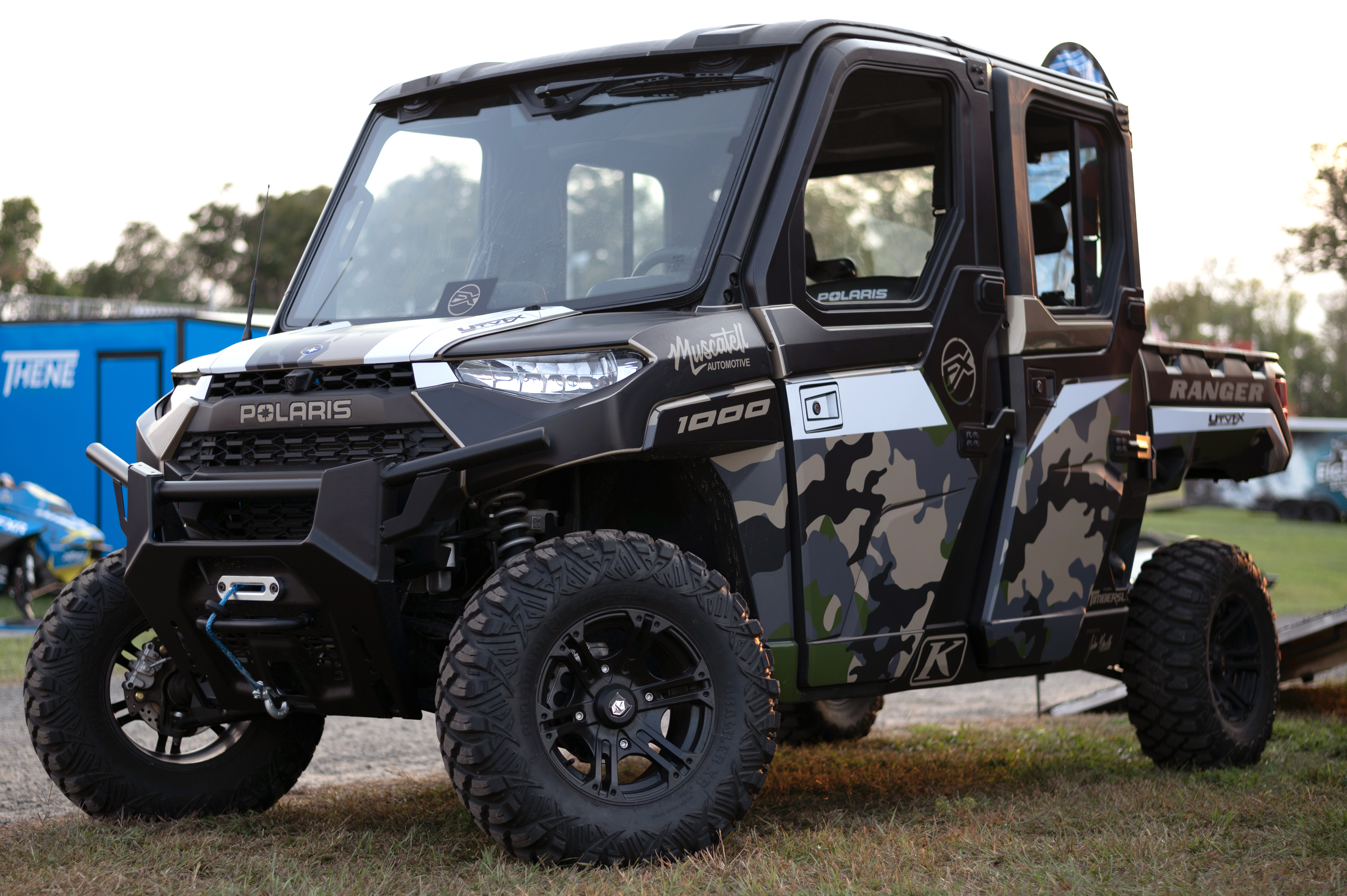 A Polaris Ranger 4 Door side-by-side with a green, black camo custom vinyl wrap.
