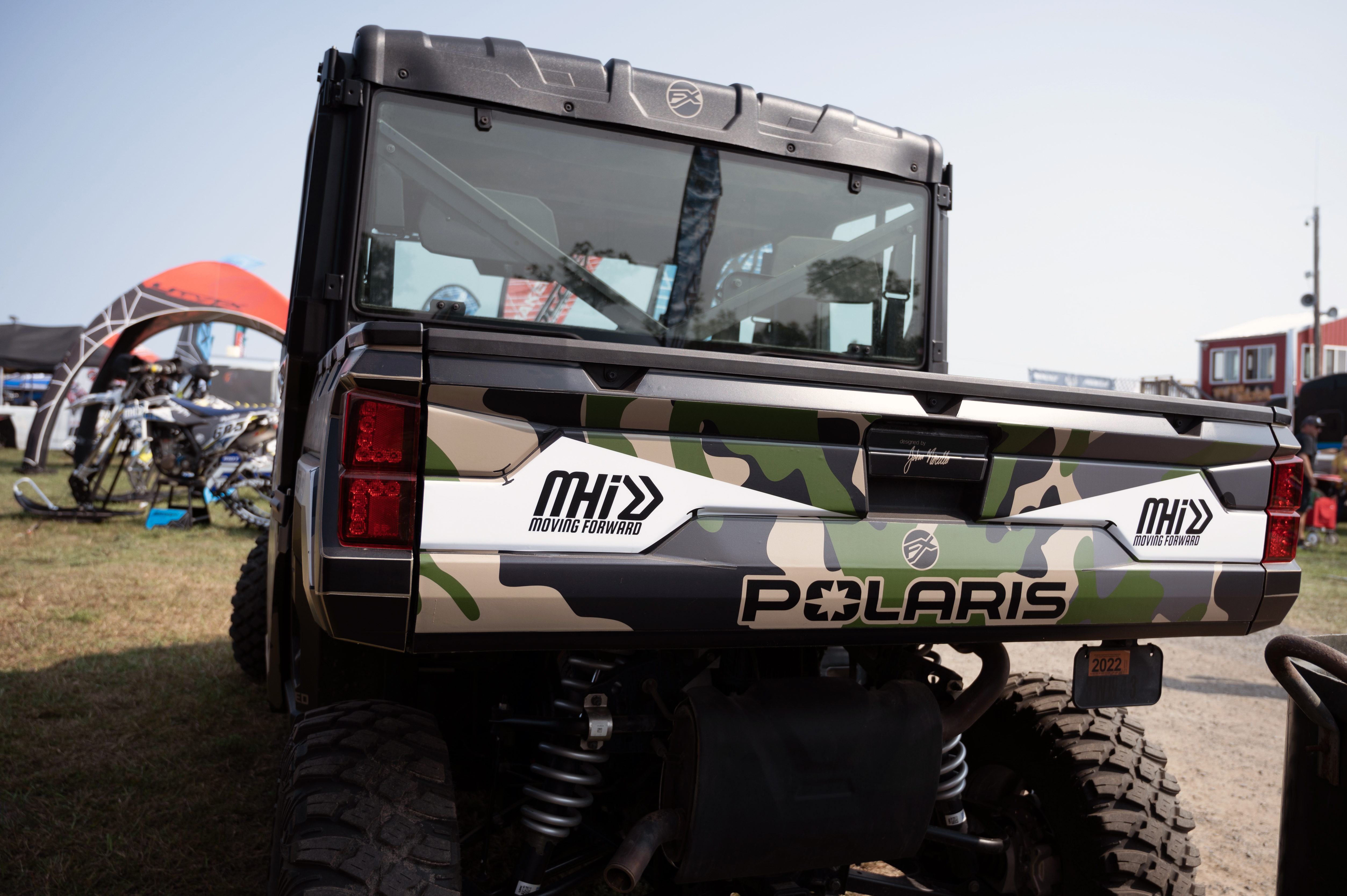 A Polaris Ranger 4 Door side-by-side with a green, black camo custom vinyl wrap.