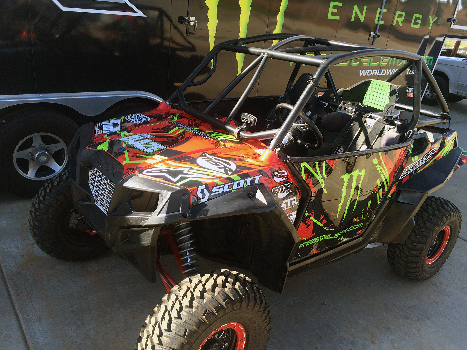 A Polaris RZR 2 Door side-by-side with a black and green Jimmy Blaze custom vinyl wrap.