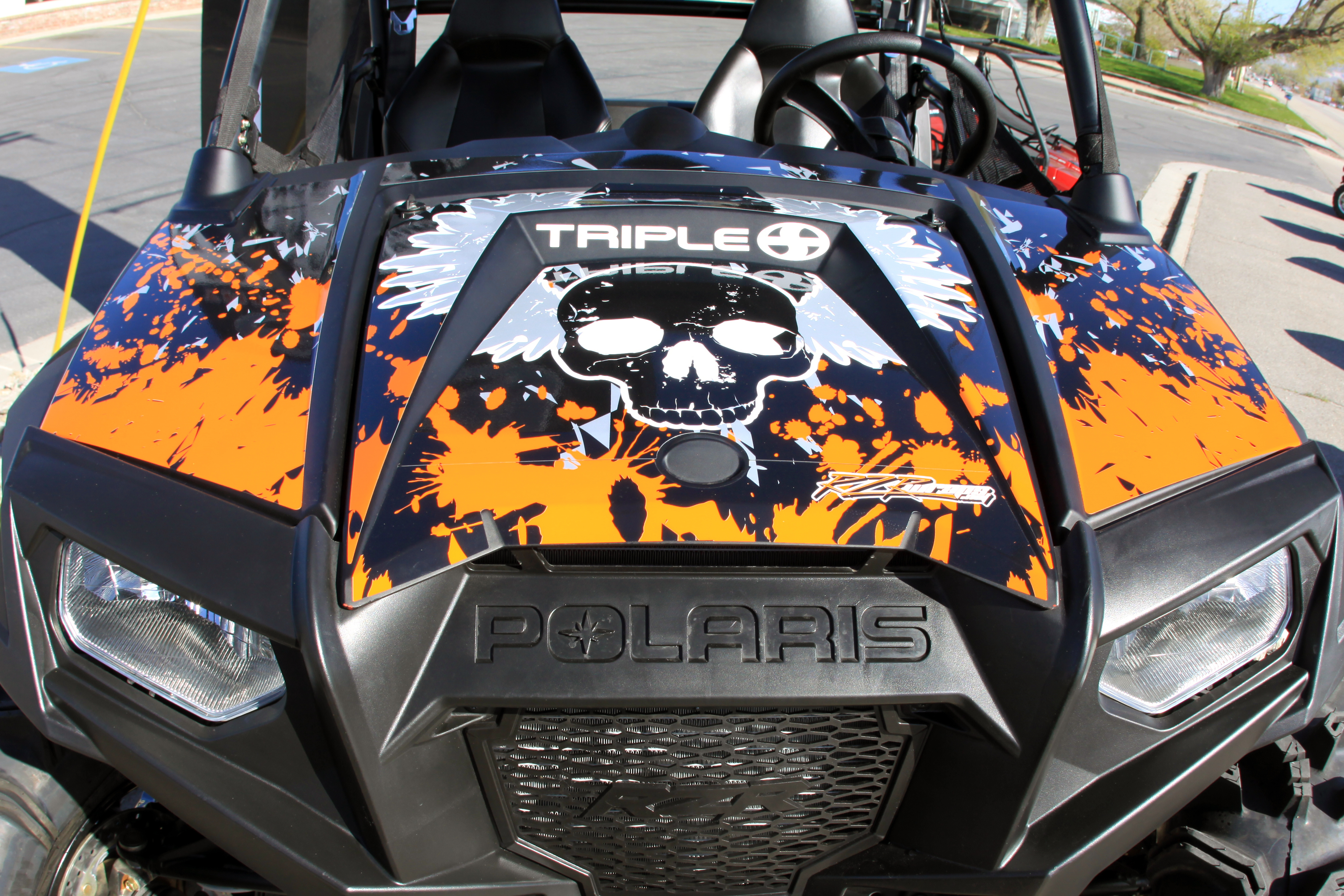 A Polaris RZR 2 Door side-by-side with an orange and black mortal flight custom vinyl wrap.