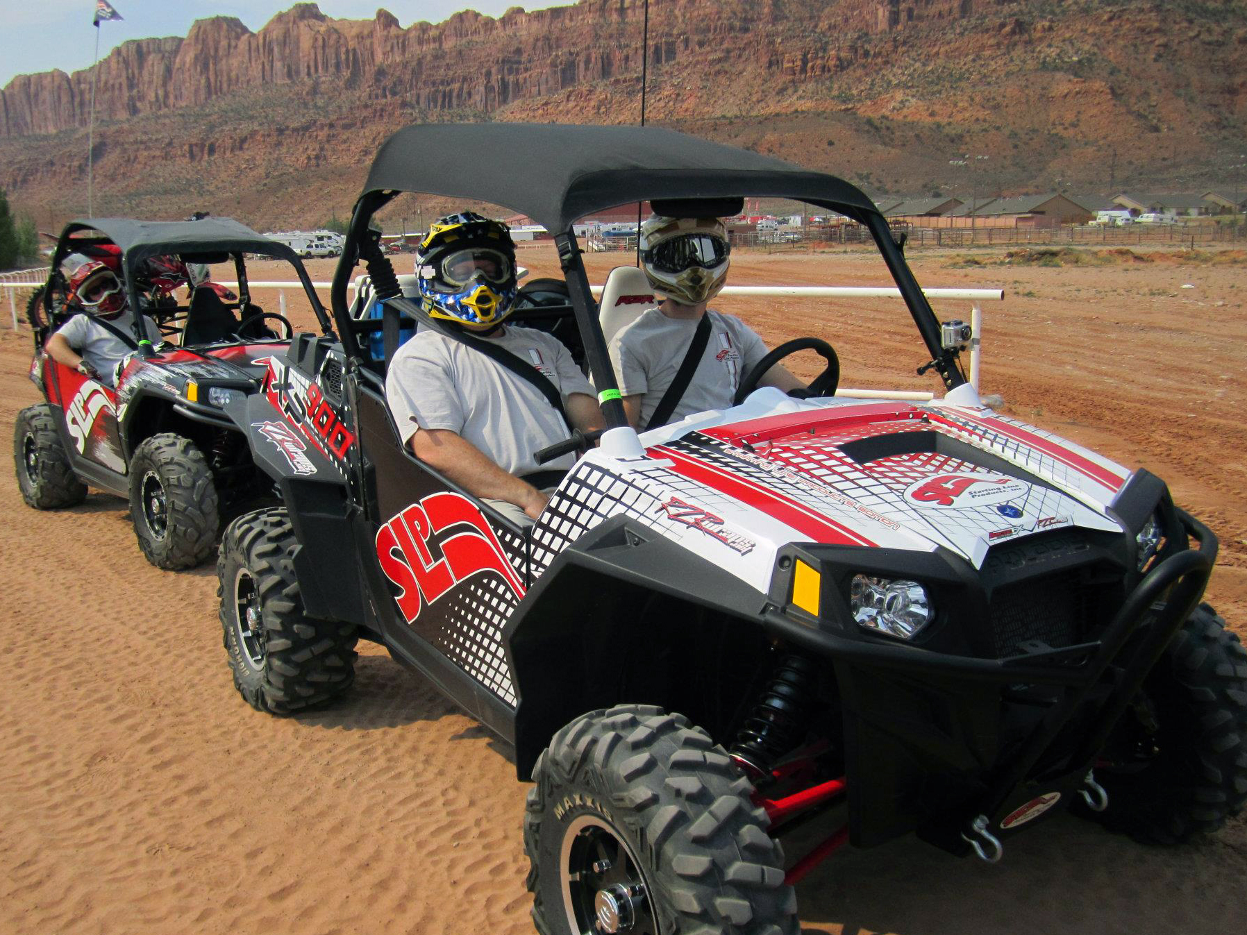 A Polaris RZR 2 Door side-by-side with a red and white SLP custom vinyl wrap.
