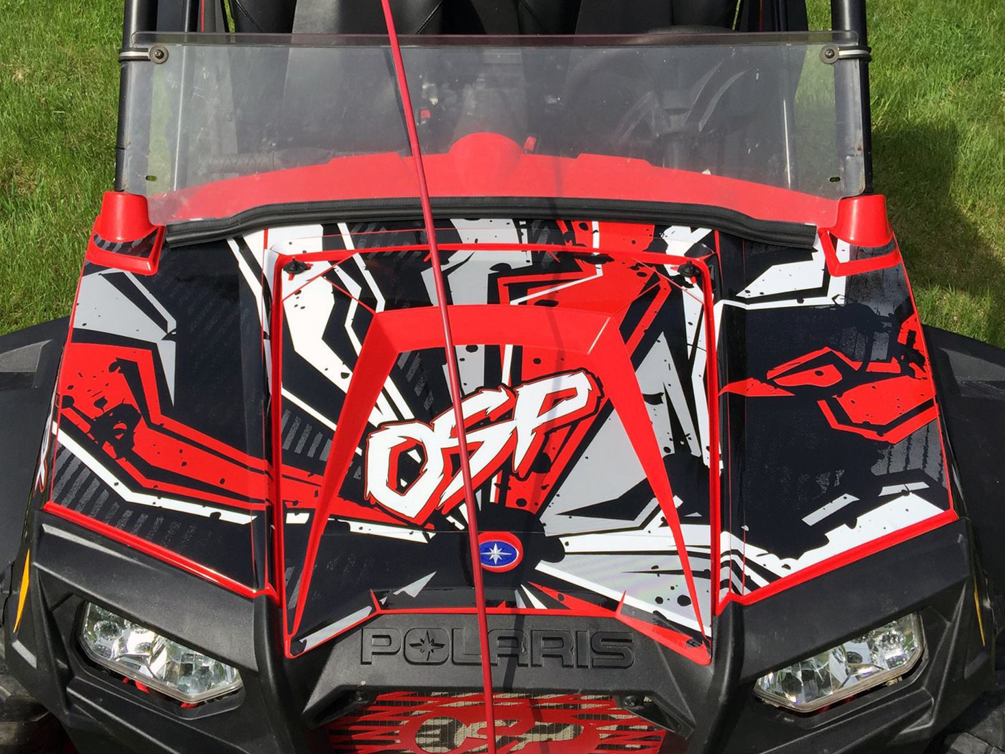 A Polaris RZR 2 Door side-by-side with a red and white Stricken custom vinyl wrap.