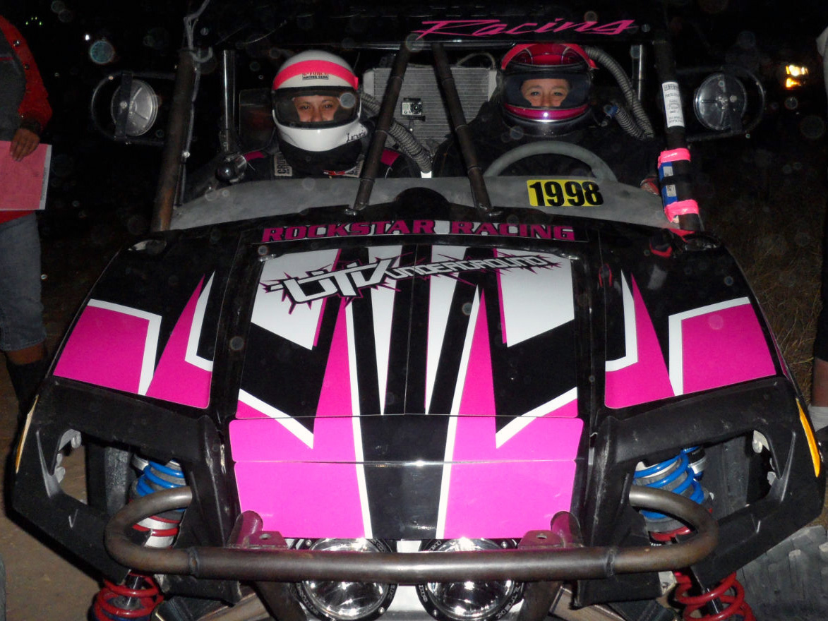 A Polaris RZR 2 Door side-by-side with a black and pink racing custom vinyl wrap.
