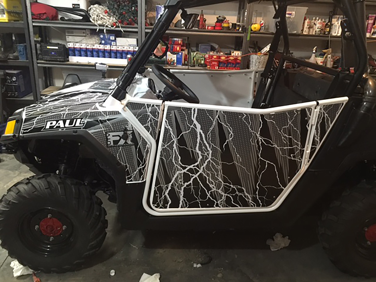 A Polaris RZR 2 Door side-by-side with a black and white Vitalize custom vinyl wrap.