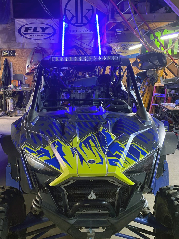 A Polaris RZR PRO XP 4 Door side-by-side with a lime squeeze, blue, and gray grunge mountain Altitude custom vinyl wrap.