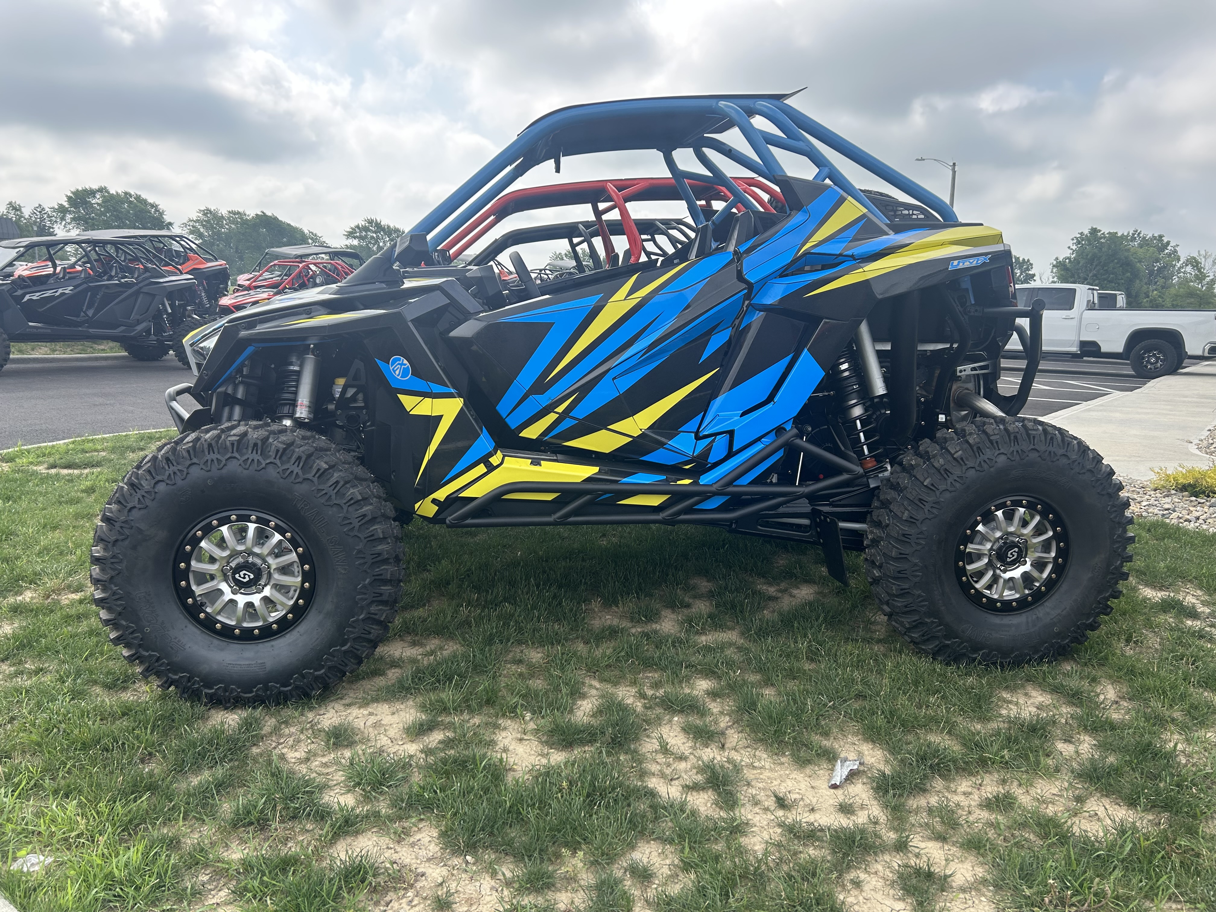 A Polaris RZR PRO XP 2 Door side-by-side with a lime squeeze, blue, and black evolution custom vinyl wrap.