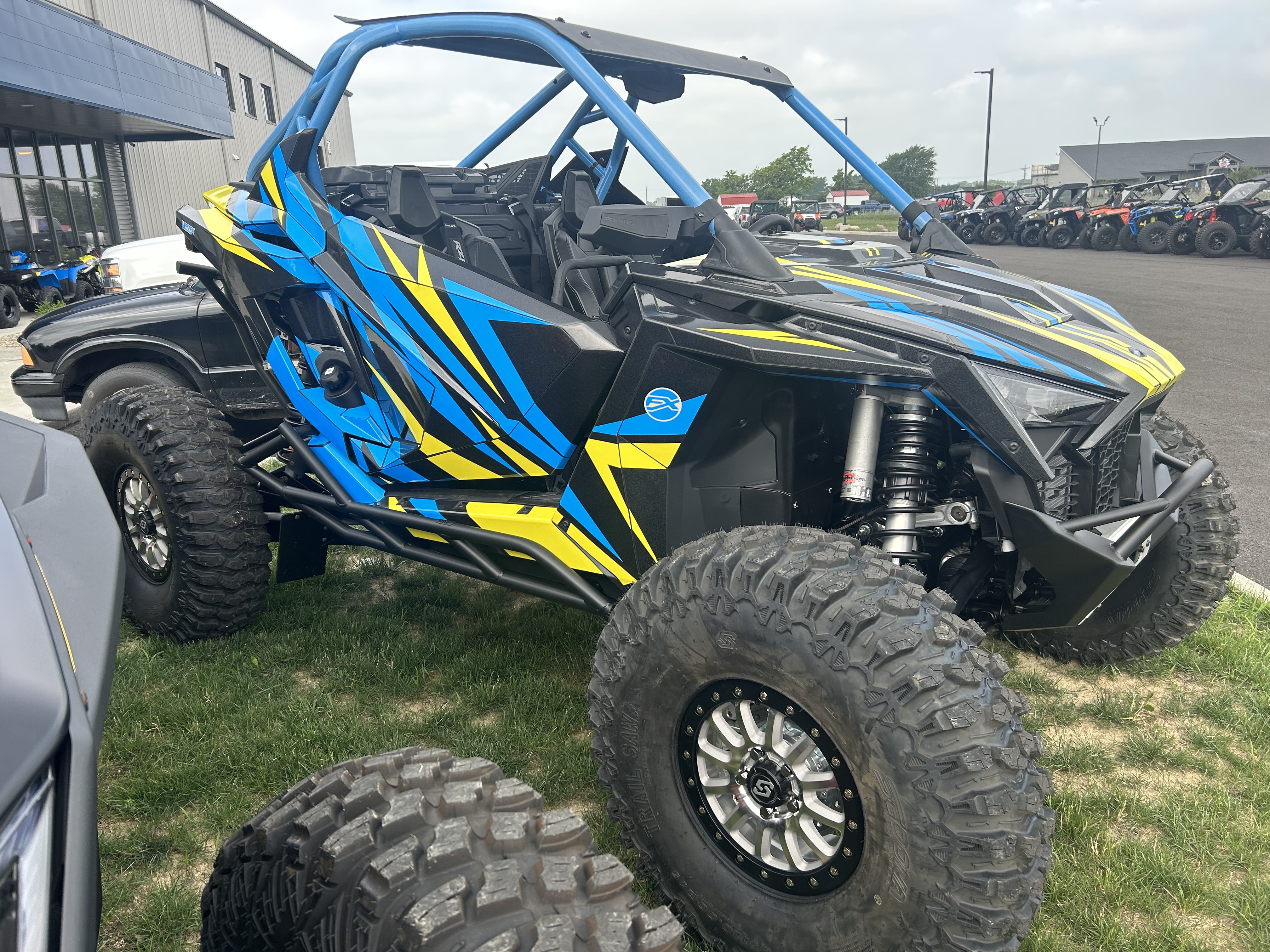 A Polaris RZR PRO XP 2 Door side-by-side with a lime squeeze, blue, and black evolution custom vinyl wrap.