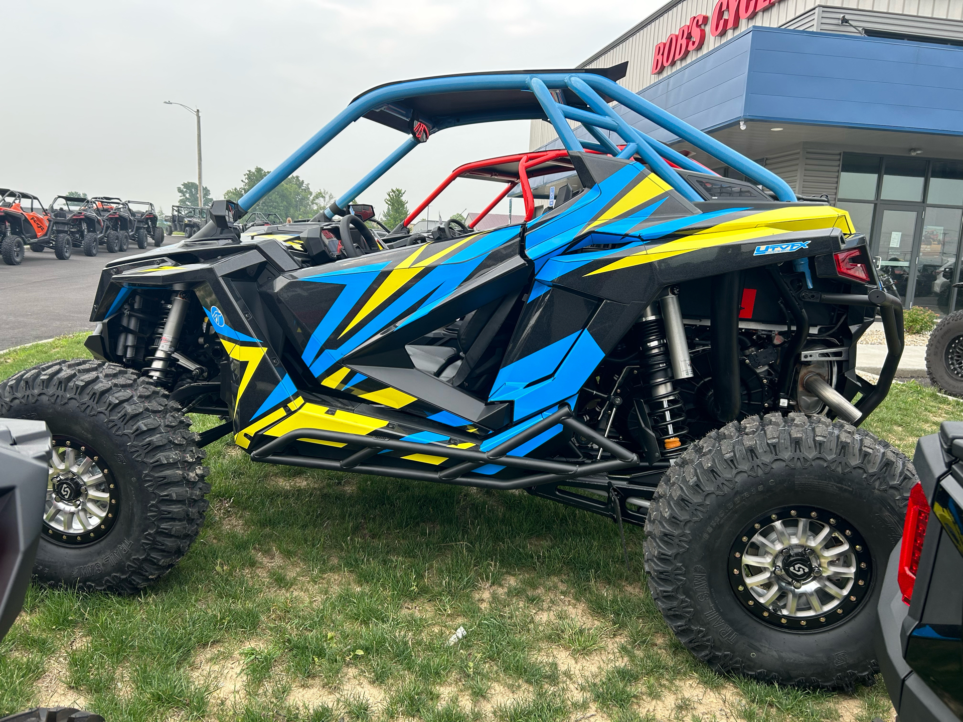 A Polaris RZR PRO XP 2 Door side-by-side with a lime squeeze, blue, and black evolution custom vinyl wrap.