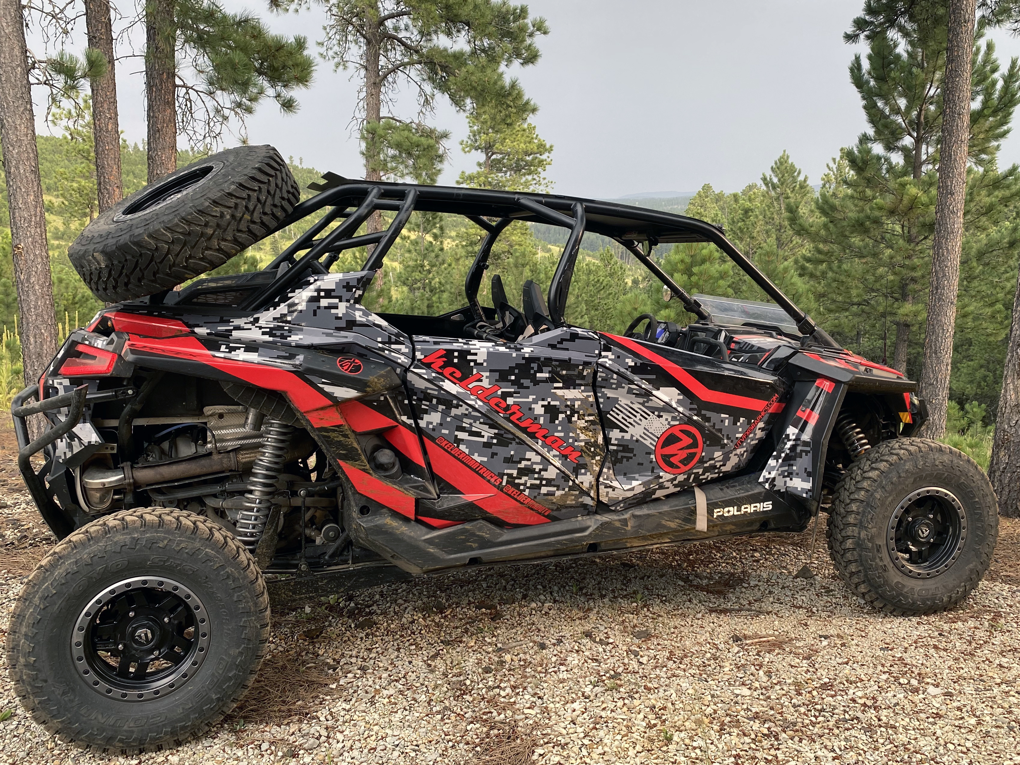 A Polaris RZR PRO XP 4 Door side-by-side with a red, black, and white digital camo custom custom vinyl wrap.
