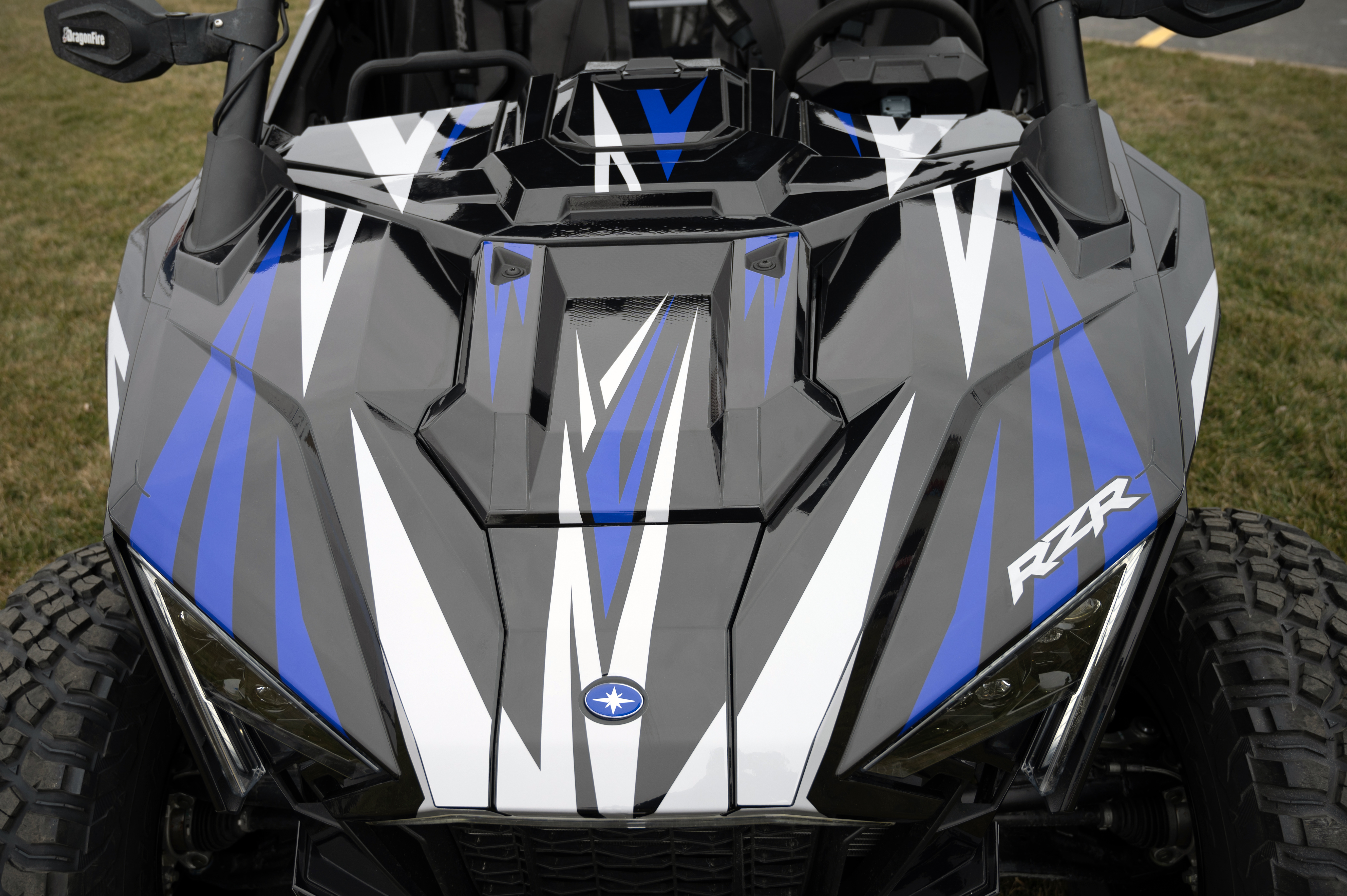 A Polaris RZR PRO XP 4 Door side-by-side with a blue and black stripes Evolution custom vinyl wrap.