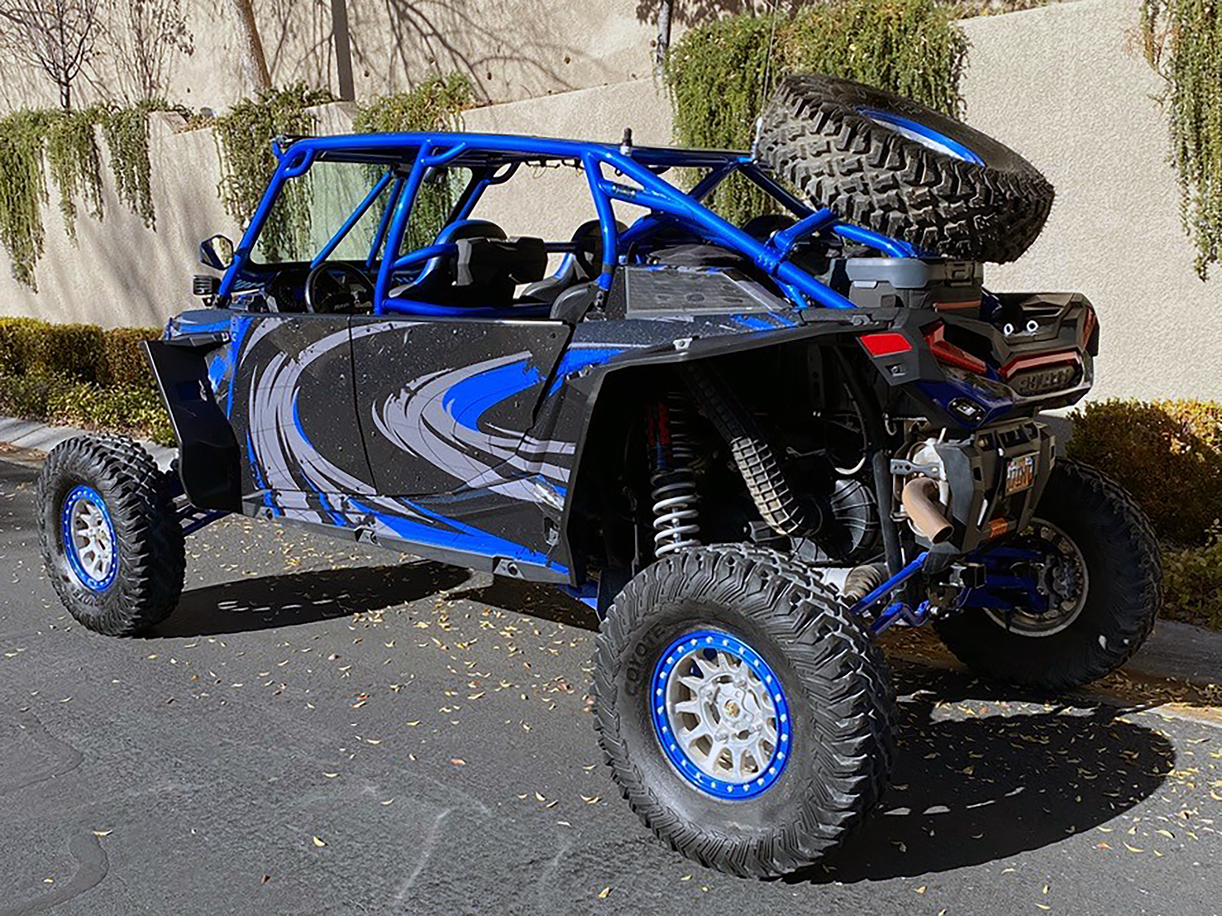 A Polaris RZR XP 4 Door 2018+ side-by-side with a black, gray, and blue grunge swirl Surge custom vinyl wrap.