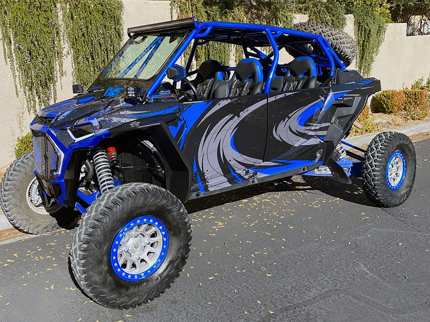 A Polaris RZR XP 4 Door 2018+ side-by-side with a black, gray, and blue grunge swirl Surge custom vinyl wrap.