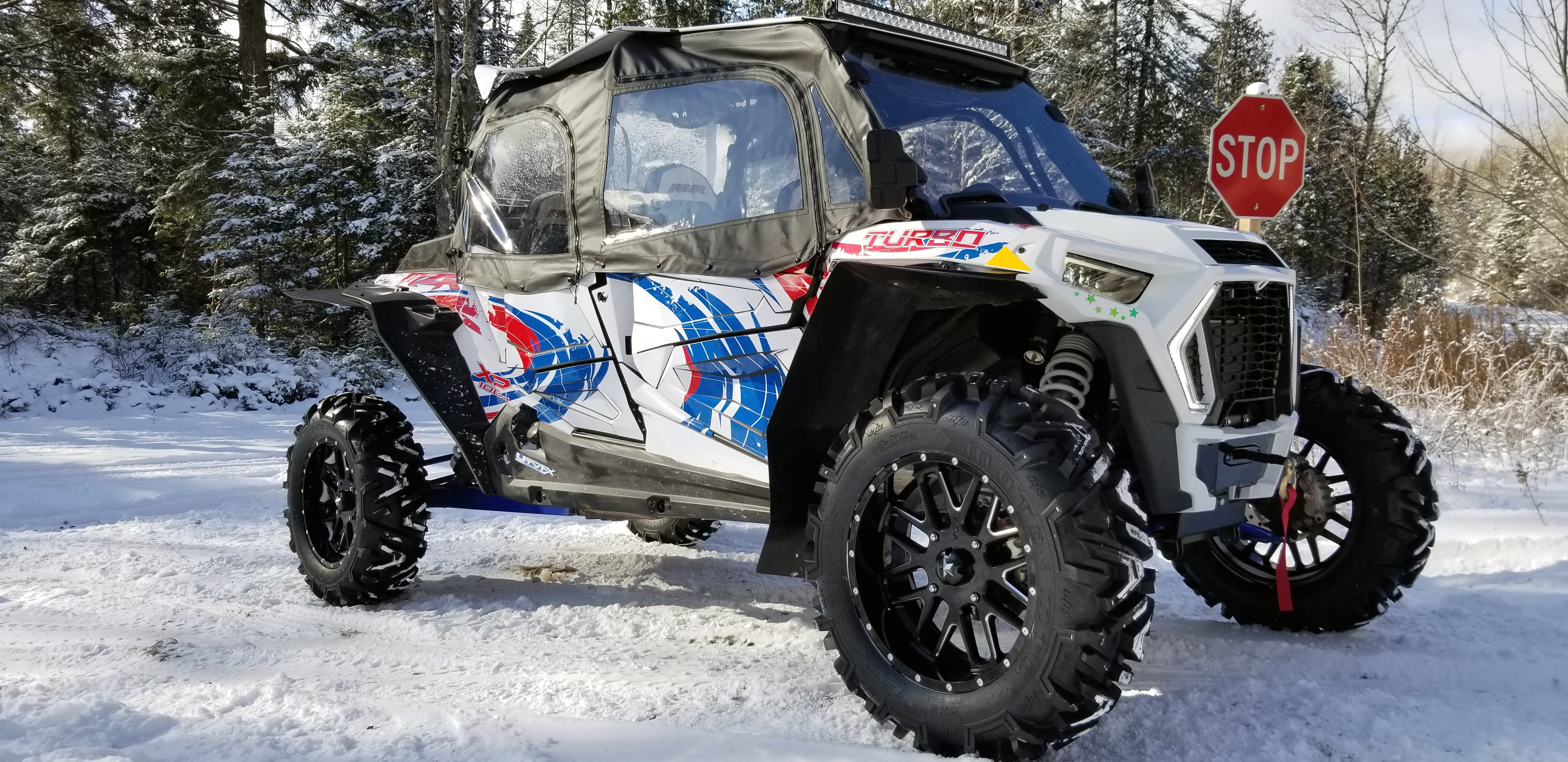 A Polaris RZR XP 4 Door 2018+ side-by-side with a red, white, and blue grunge swirl Surge custom vinyl wrap.