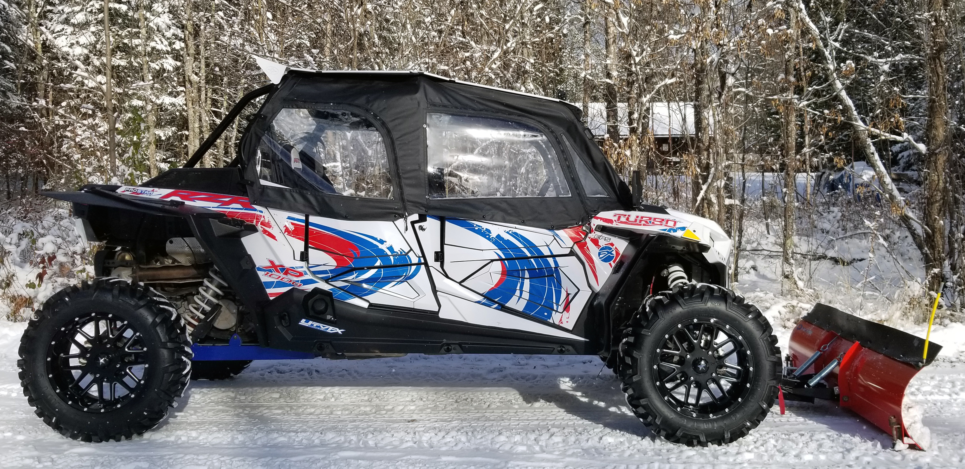 A Polaris RZR XP 4 Door 2018+ side-by-side with a red, white, and blue grunge swirl Surge custom vinyl wrap.