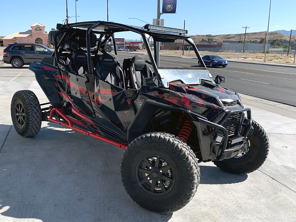 A Polaris RZR XP 4 Door 2018+ side-by-side with a red, gray, and black geometric pattern Virus custom vinyl wrap.