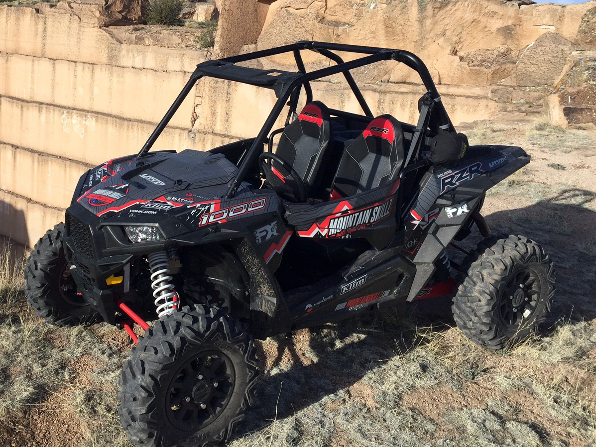 A Polaris RZR XP 2 Door side-by-side with a white, red, and black grunge mountain Entz Frontier custom vinyl wrap.