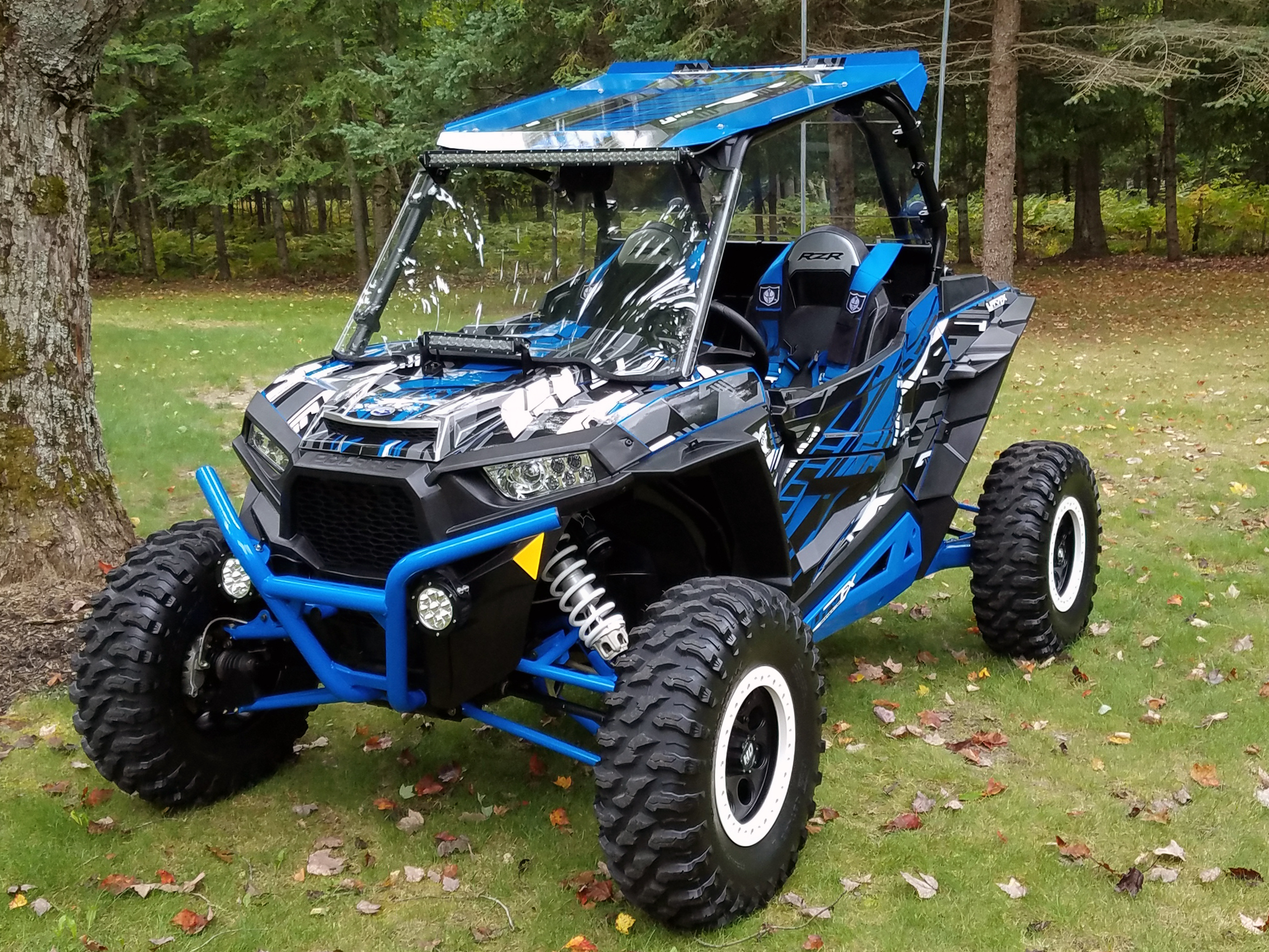 A Polaris RZR XP 2 Door side-by-side with a blue, gray, and black stripes Evasion custom vinyl wrap.