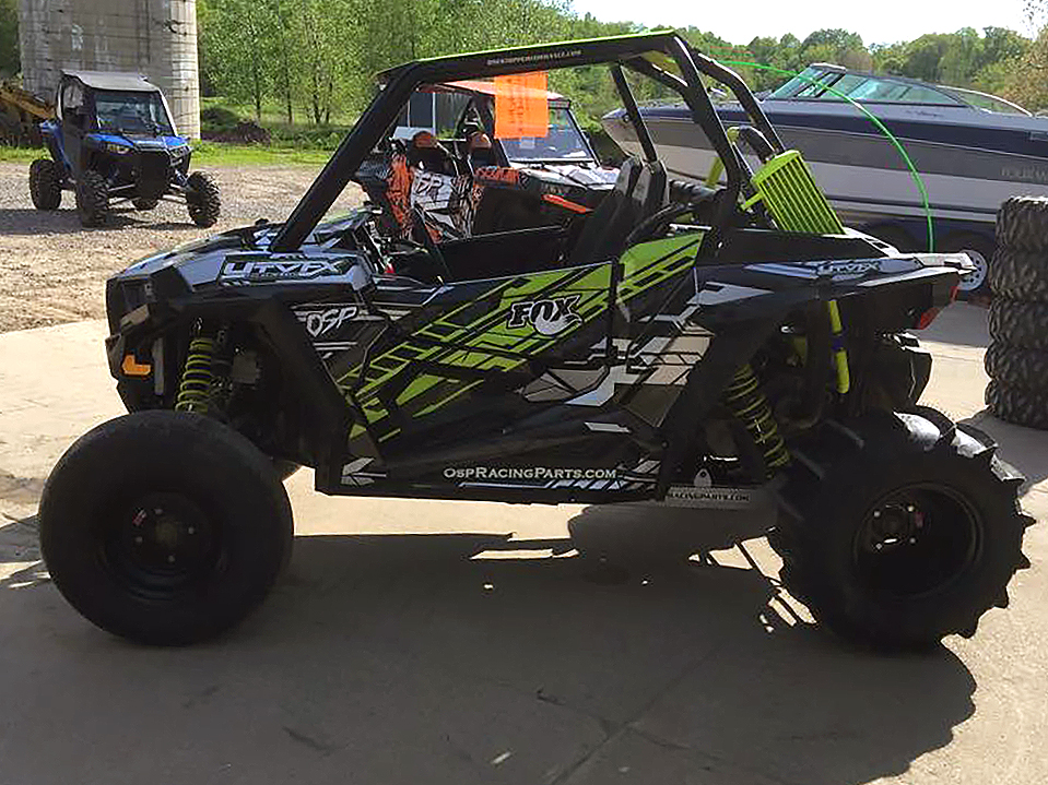 A Polaris RZR XP 2 Door side-by-side with a lime squeeze, gray, and black stripes Evasion custom vinyl wrap.
