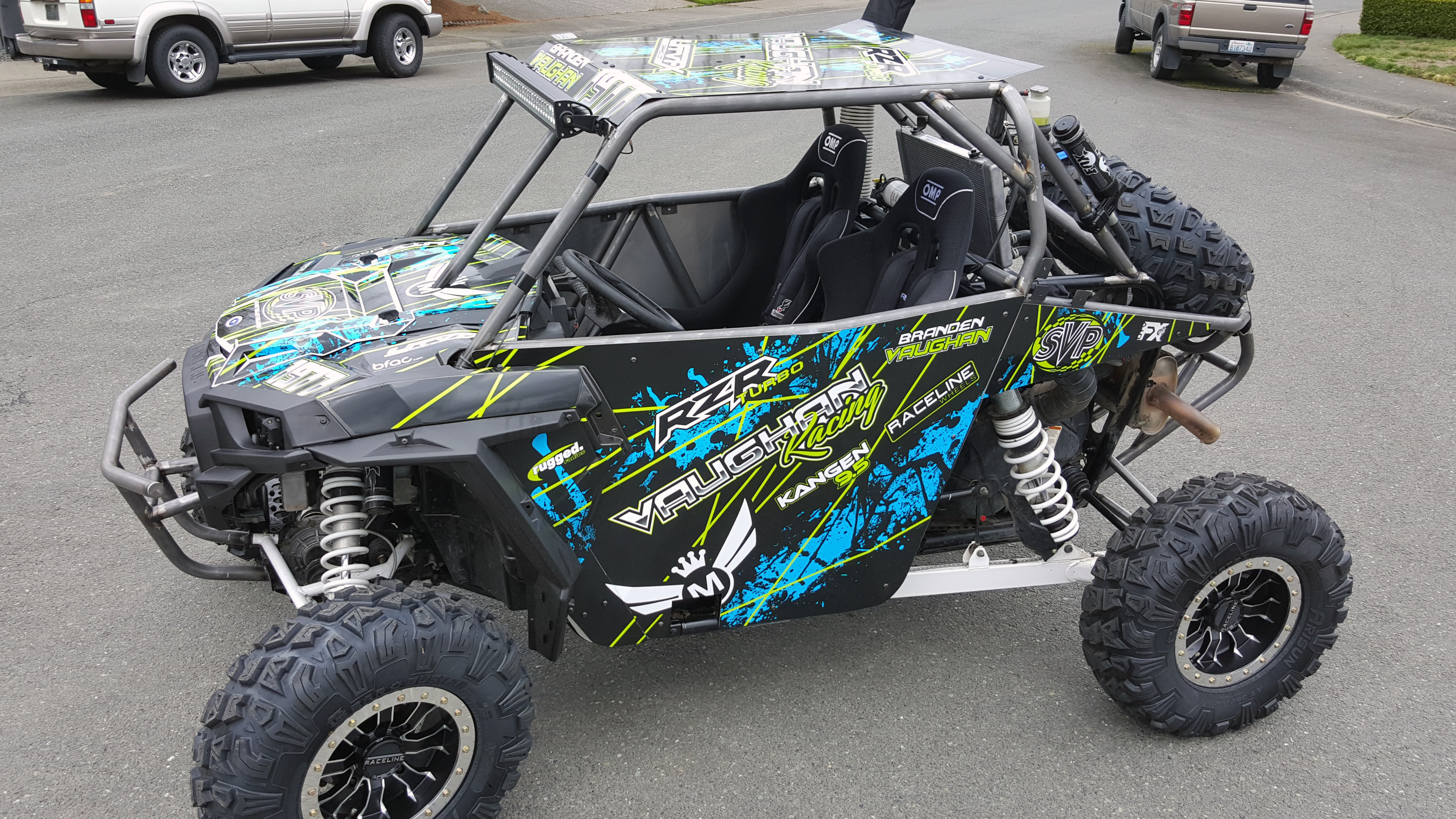 A Polaris RZR XP 2 Door side-by-side with a black, blue, and lime grunge lines Oblivion custom vinyl wrap.